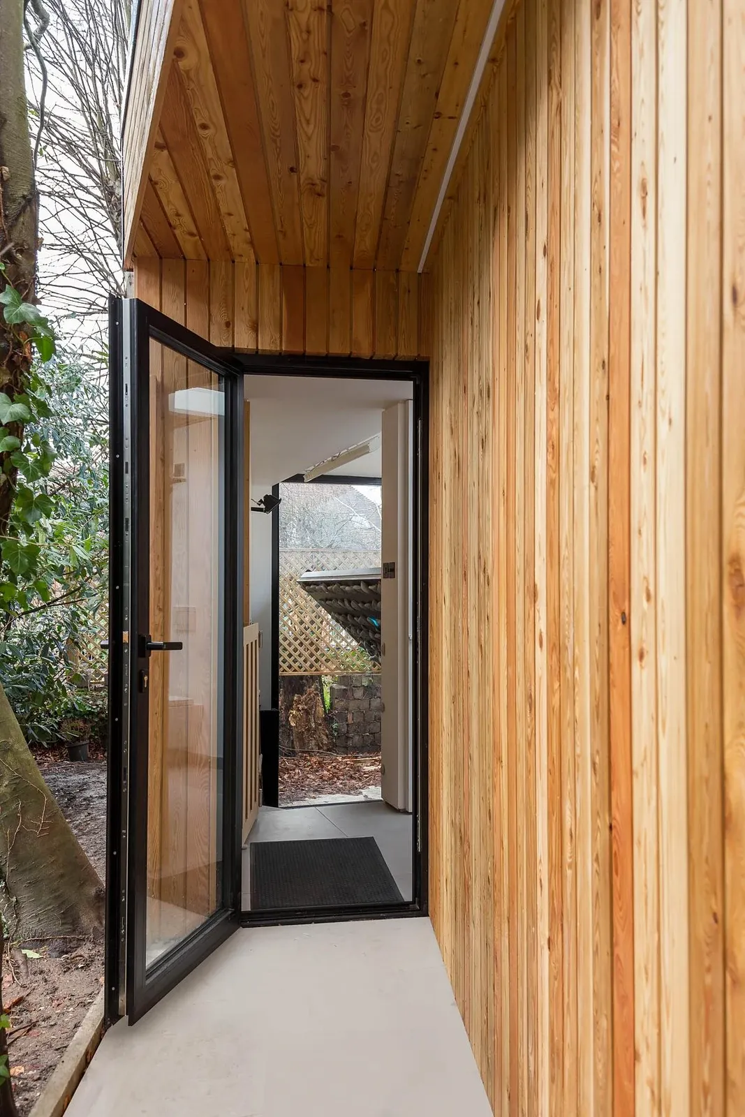 Timber-lined passage and glazed door between the pavilion volumes.