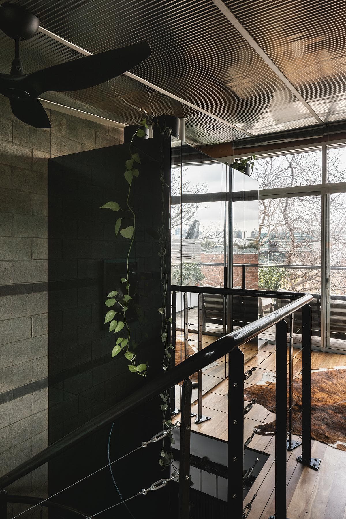 The stair passes a reflective enclosure that borrows light from the windows.