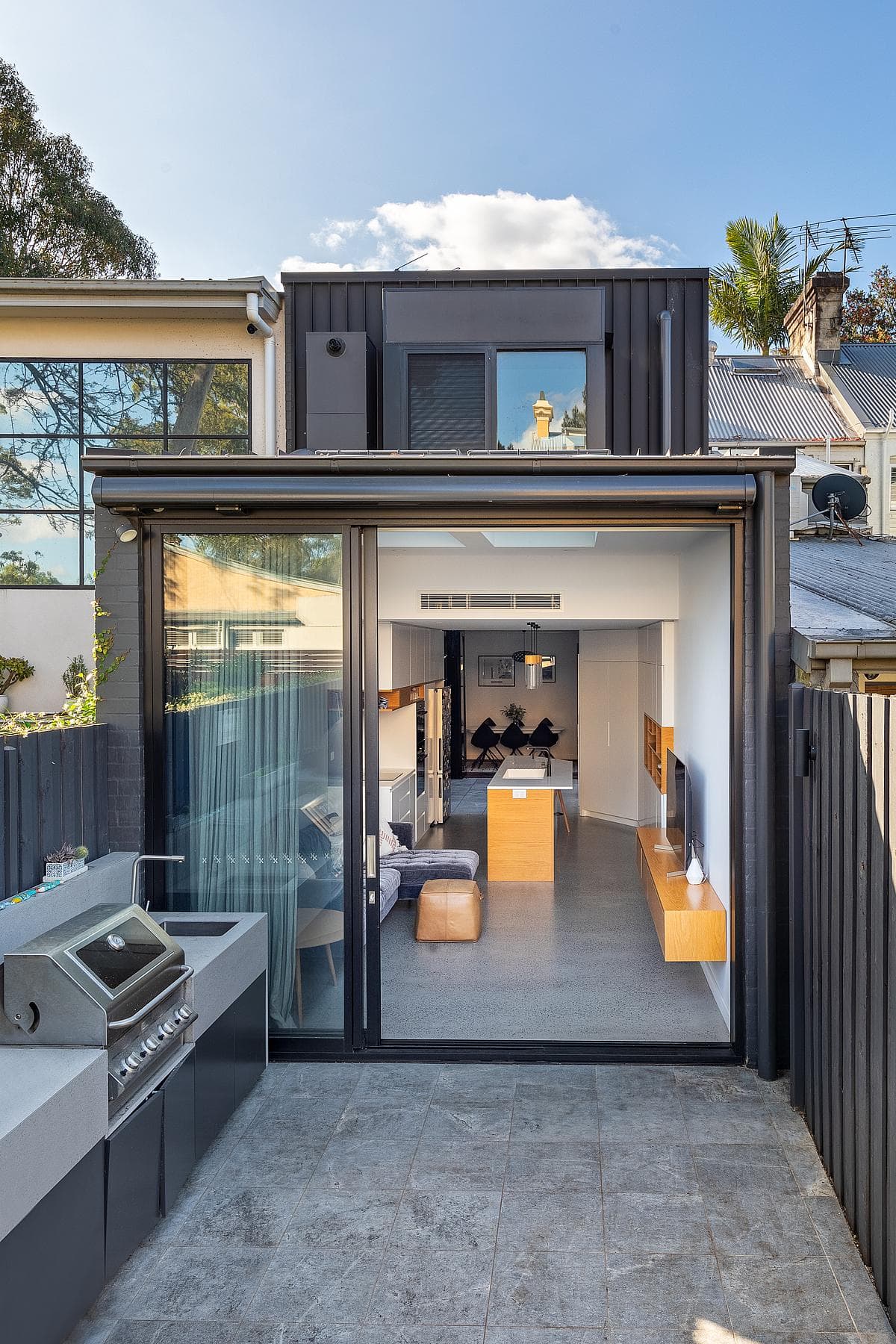 The contemporary rear extension meets a paved courtyard.