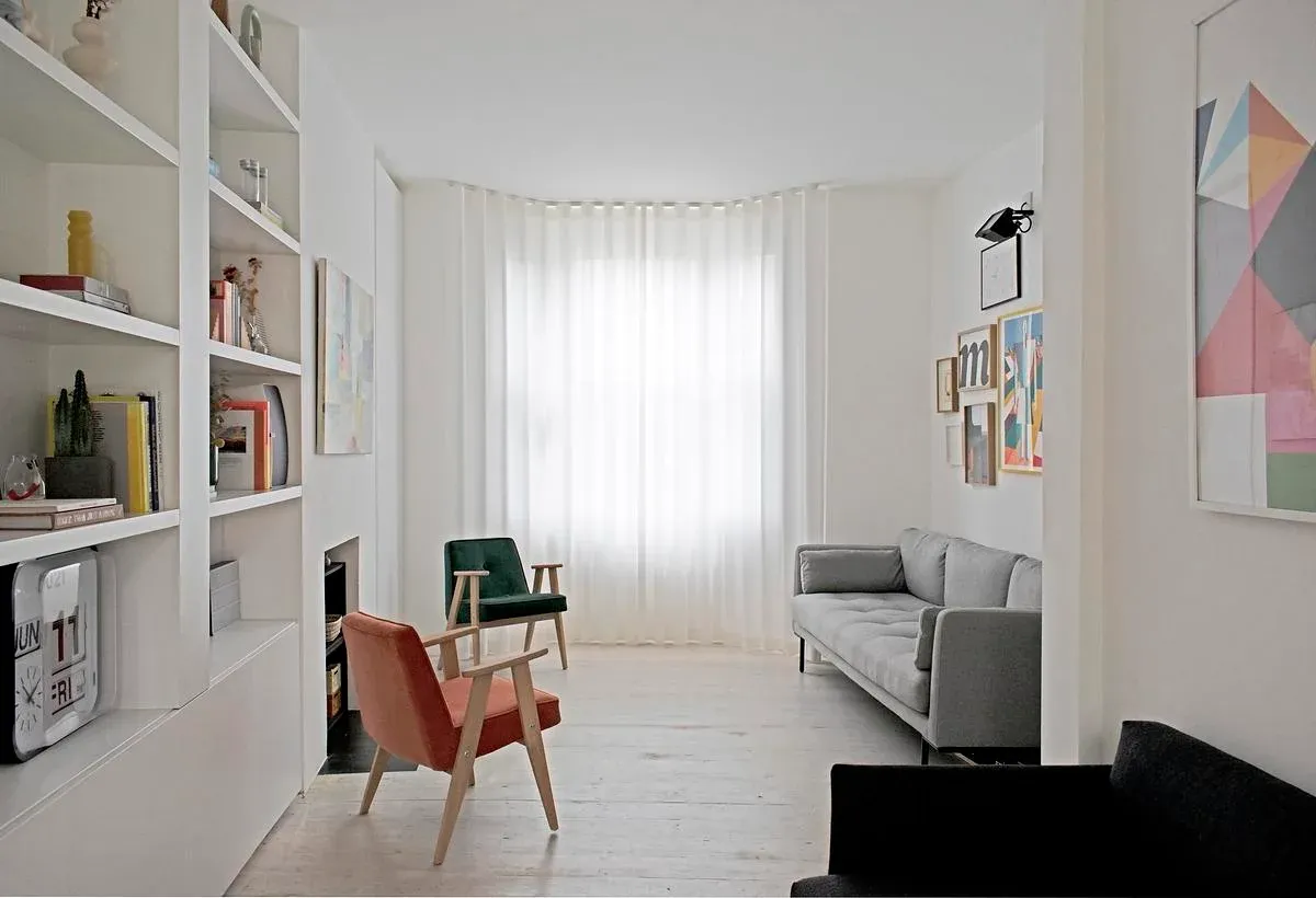 A curtain follows the living room’s original front bay window.