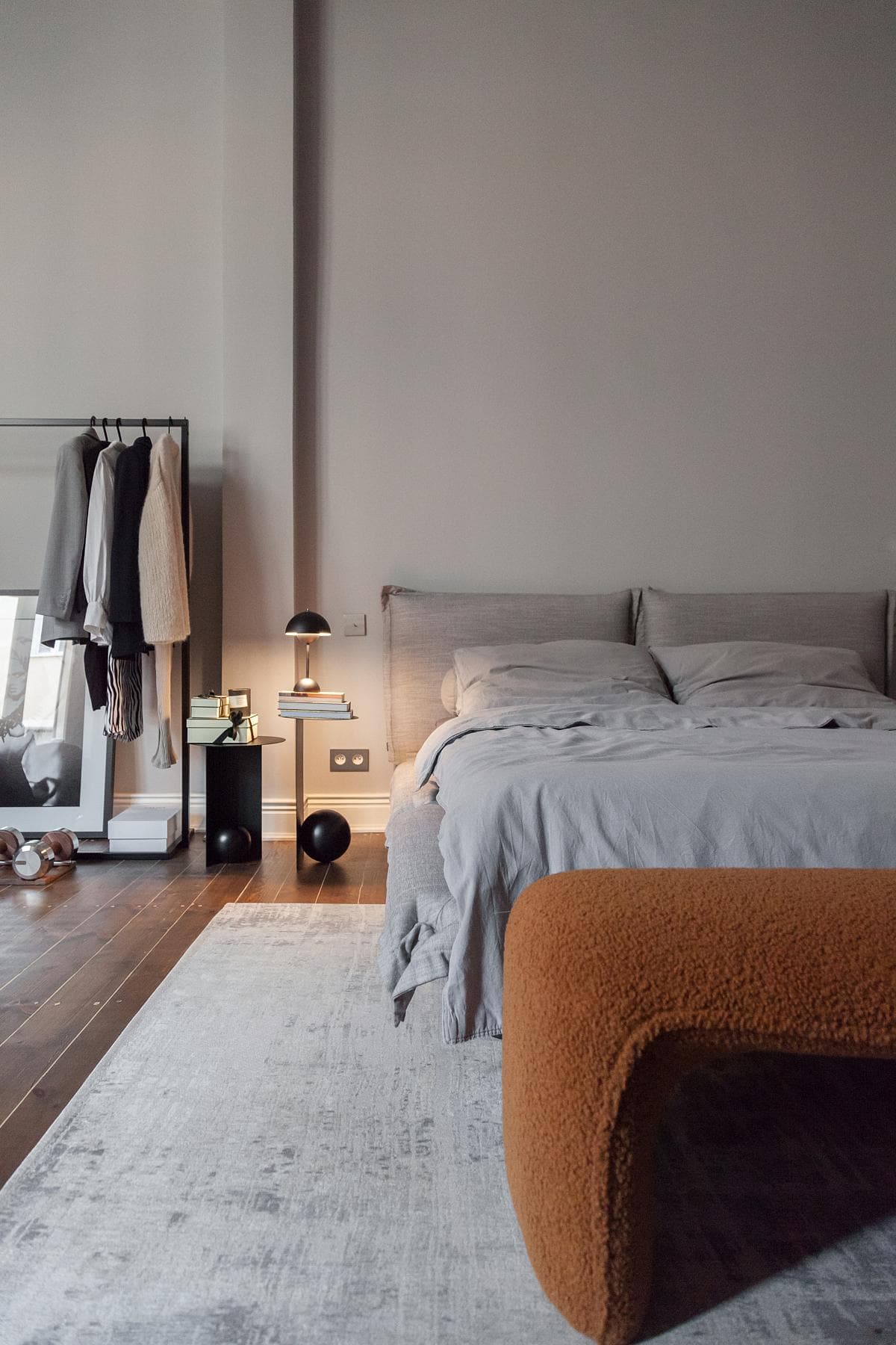 The bedroom combines restored timber flooring with a restrained palette.
