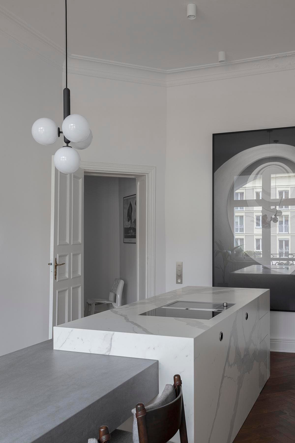 A pale kitchen island sits within the restored sequence of rooms.