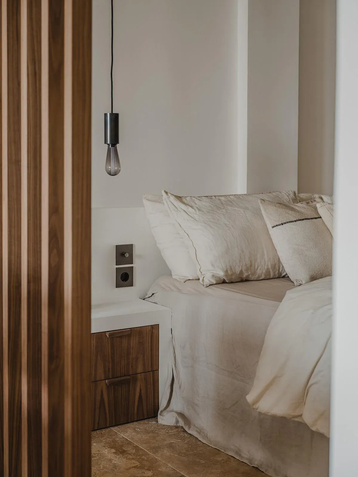 A slatted screen separates the bed from the apartment’s shared space.