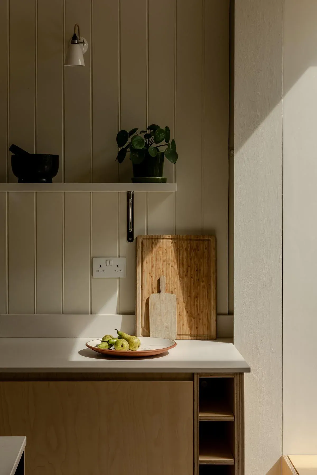 A corner of the kitchen with a worktop and open shelving.