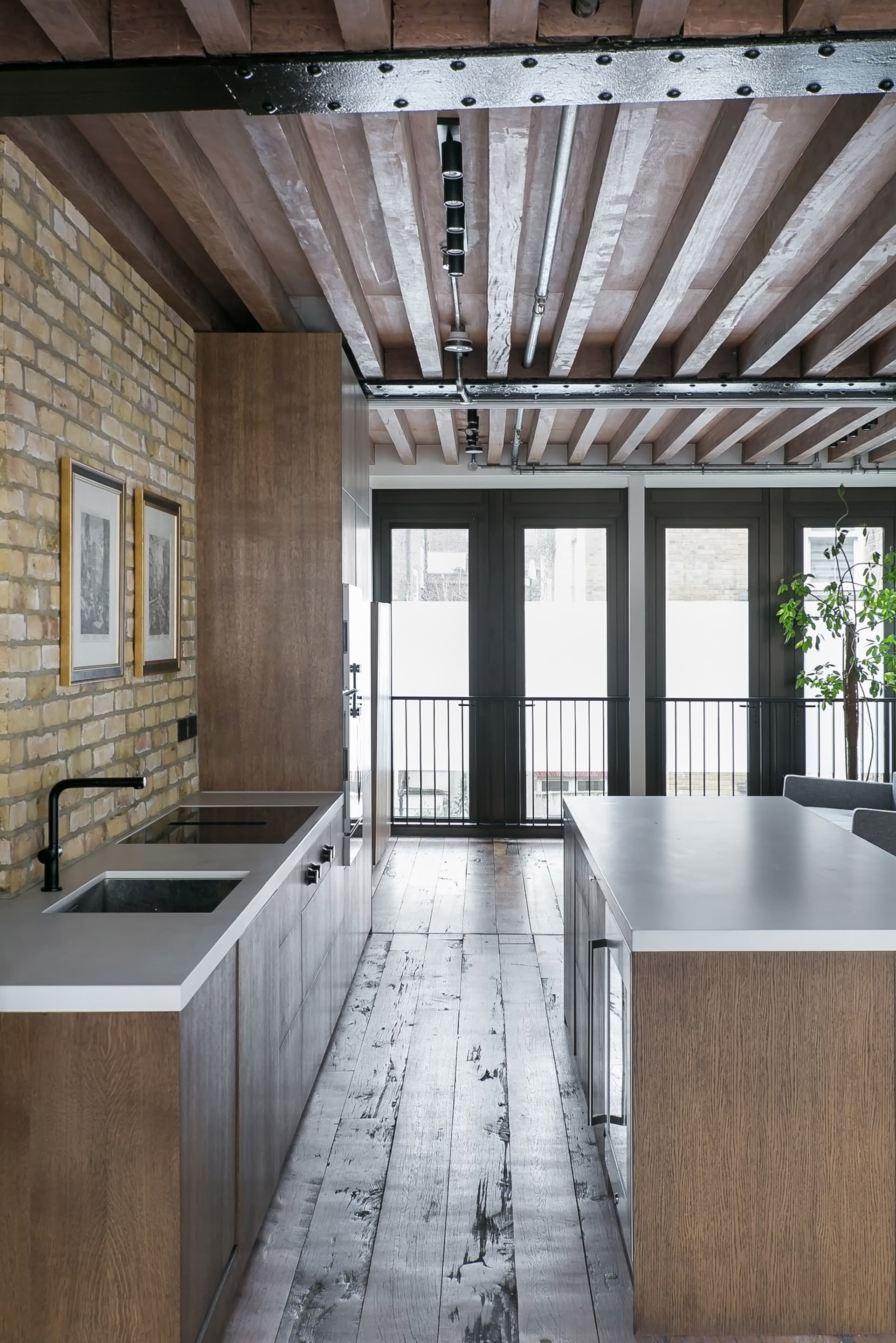 The timber-clad kitchen island follows the direction of the ceiling structure.