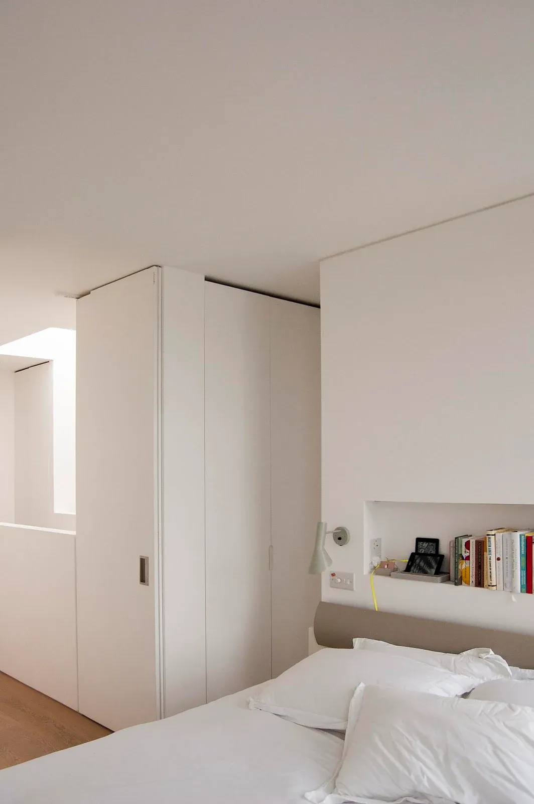 White partitions and a pocket doorway organise a bedroom at Modern Terrace.