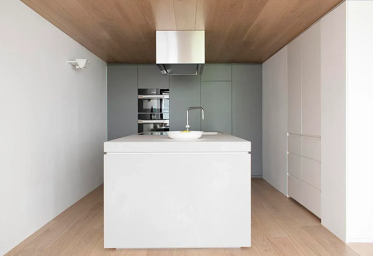 A white kitchen island sits below the timber-clad gallery floor.