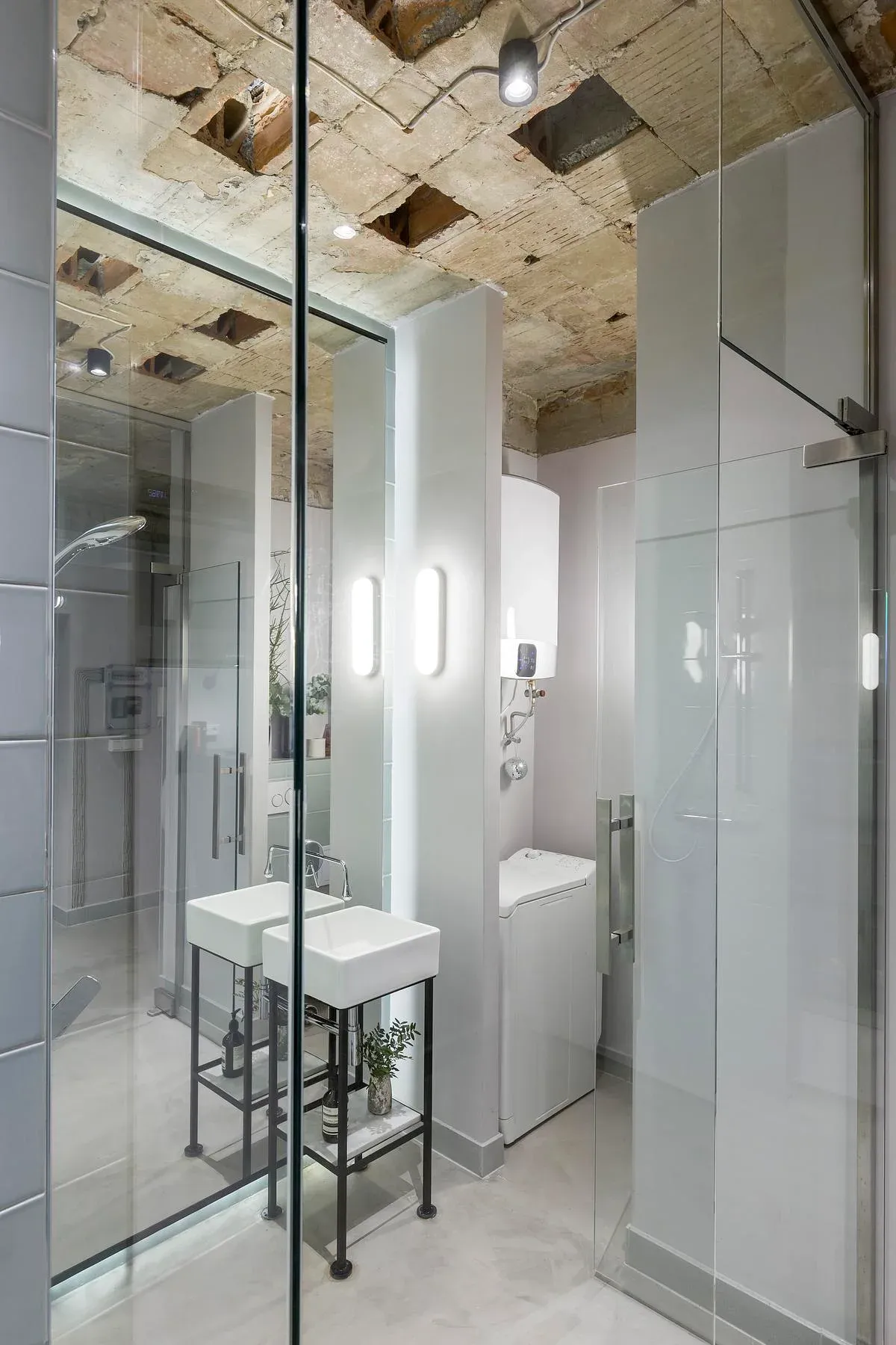 A freestanding basin and mirrored surfaces in the compact bathroom.