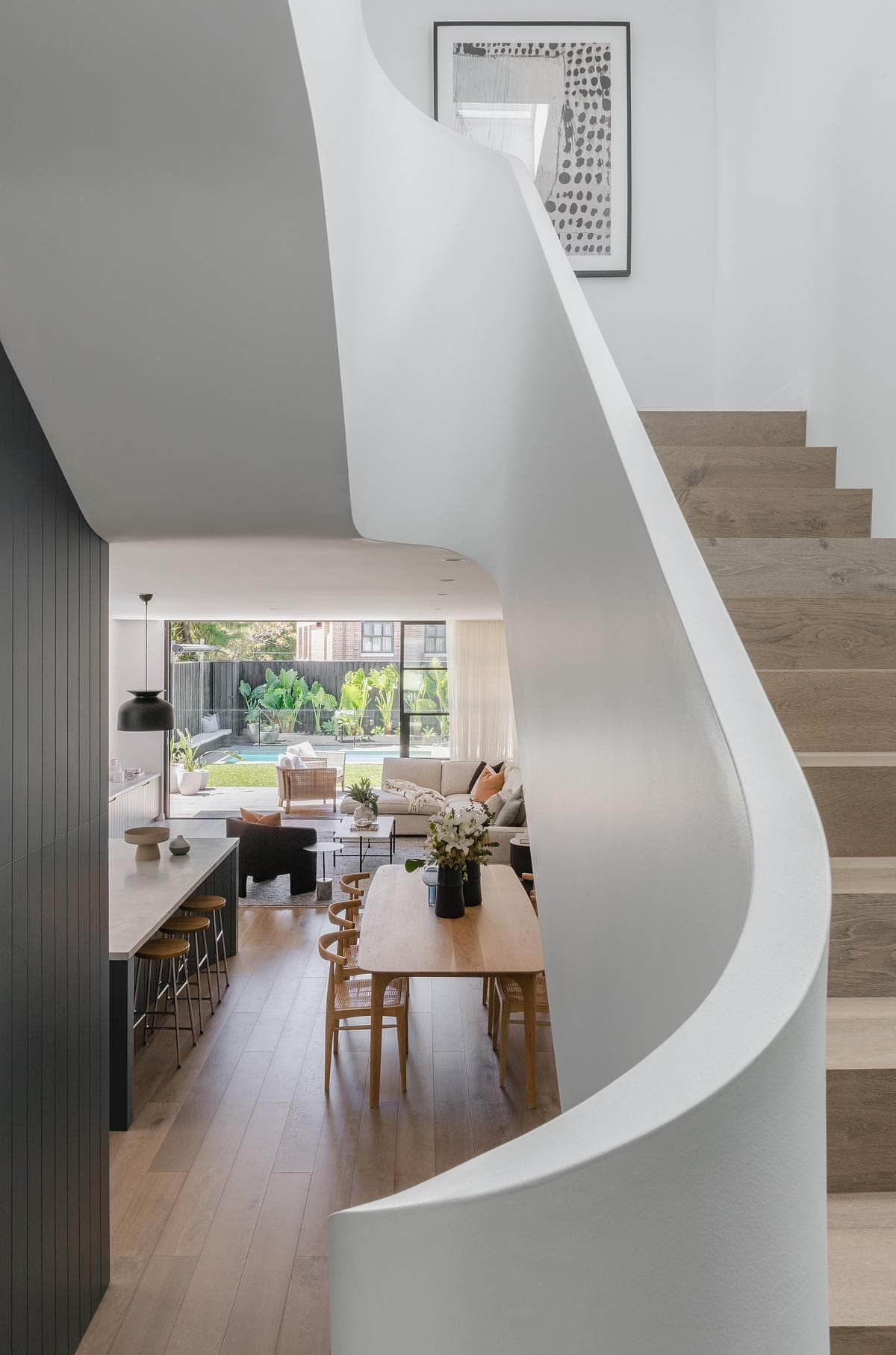 A curved stair connects the split levels and opens views into the living space.