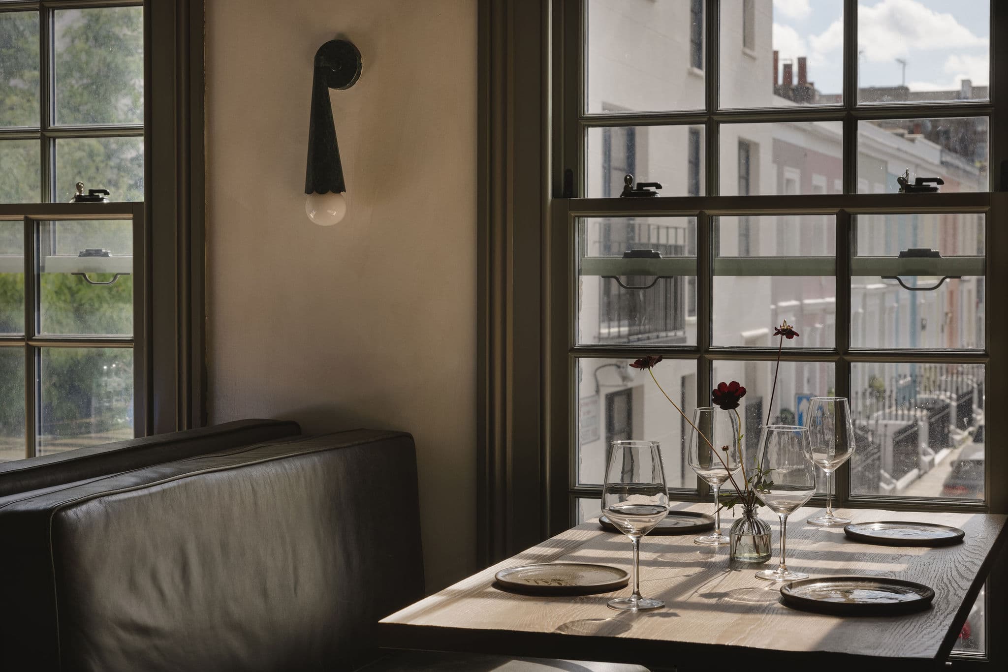 A dining table beside the townhouse’s sash window.