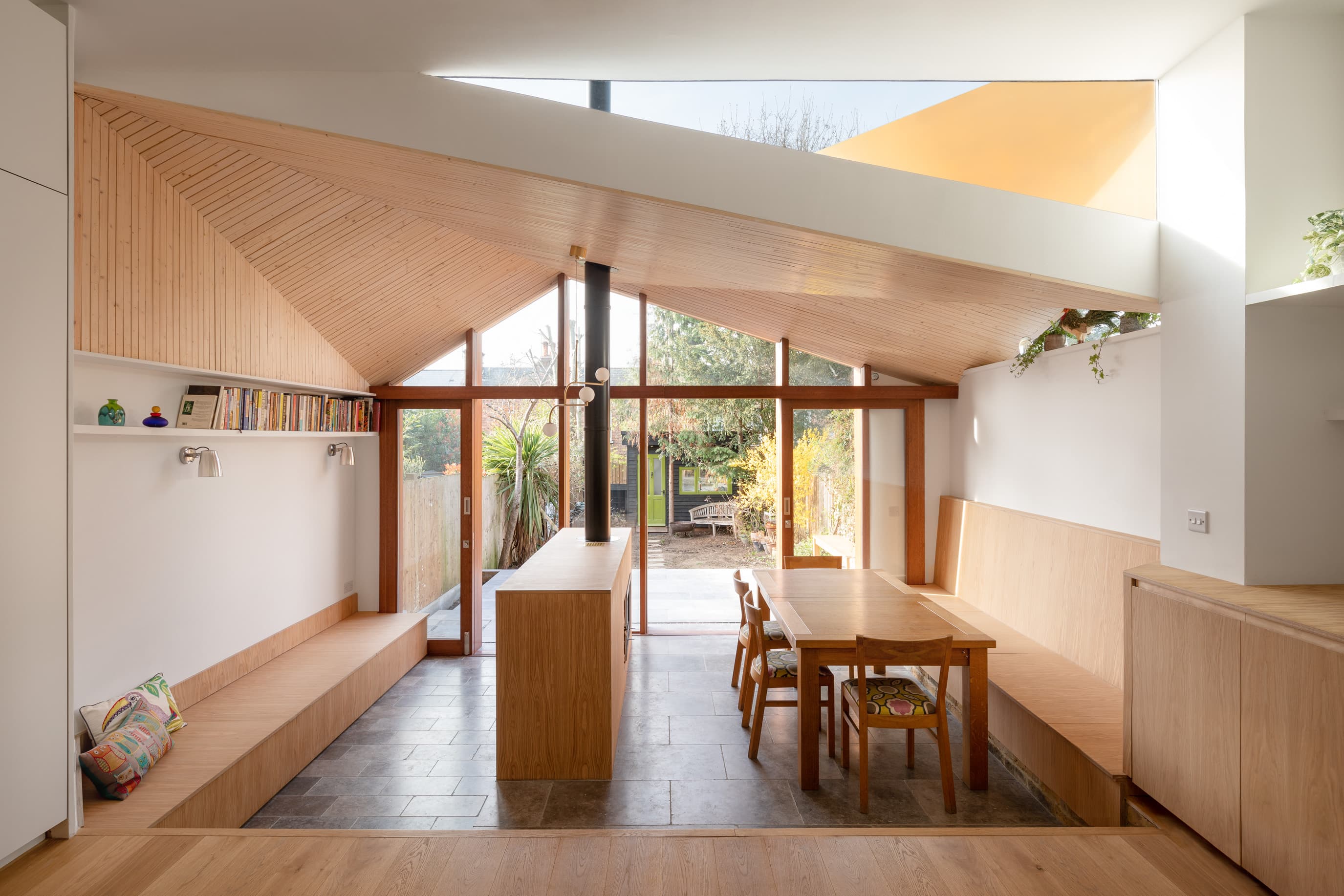 The kitchen, dining area and snug sit beneath a shaped timber ceiling.