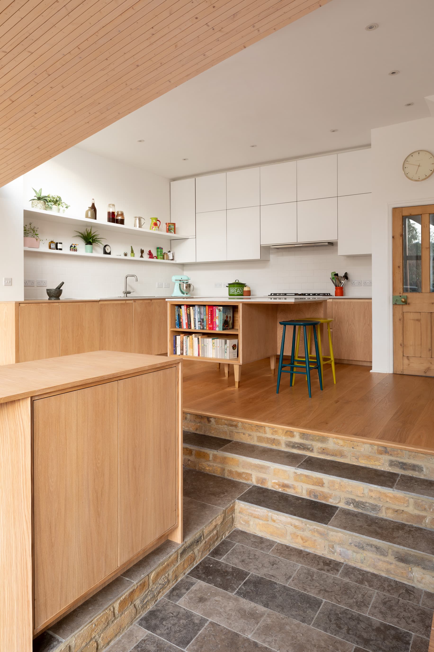 Steps connect the raised kitchen with the lower living spaces.