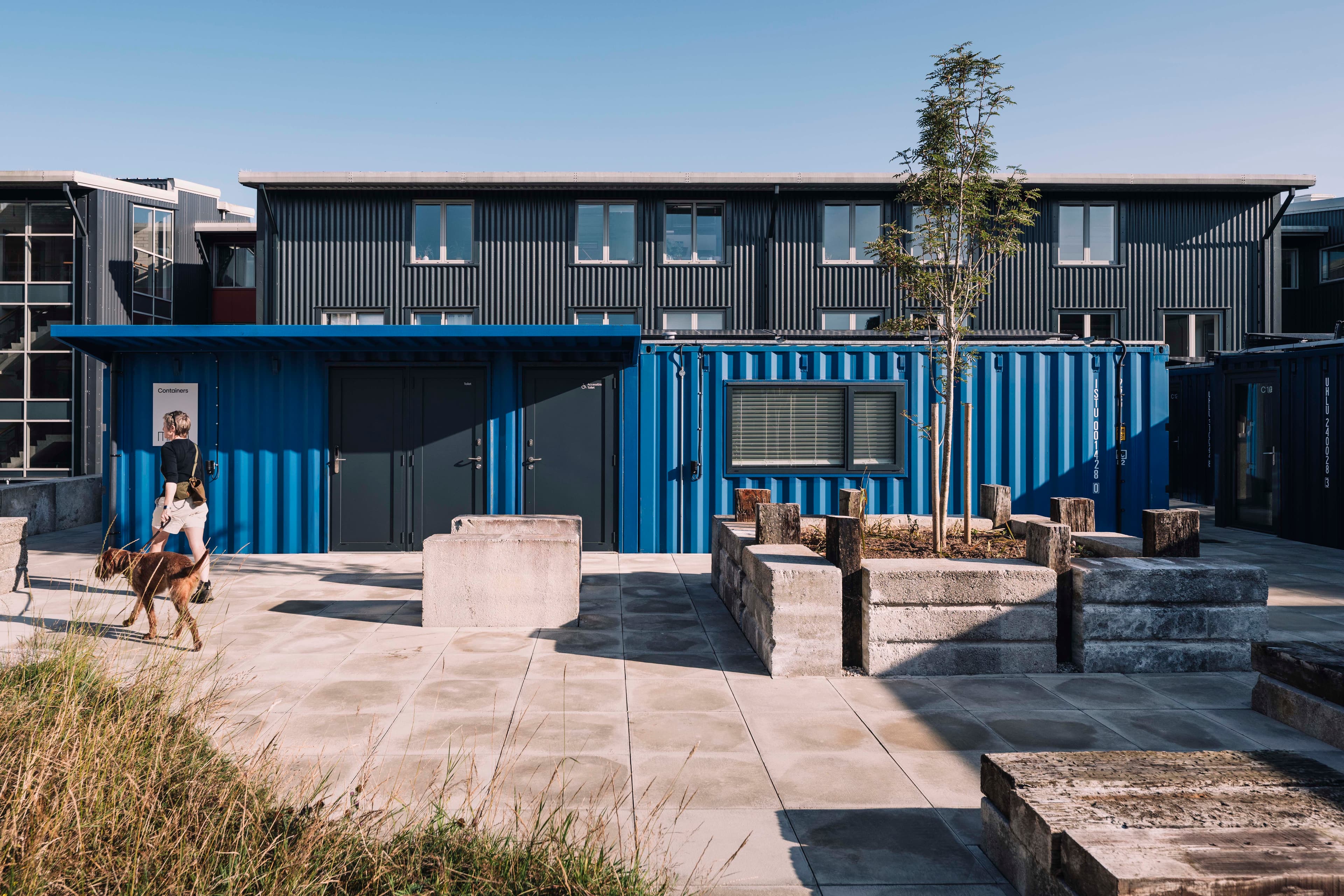Shared workspaces connect the blue container studios.