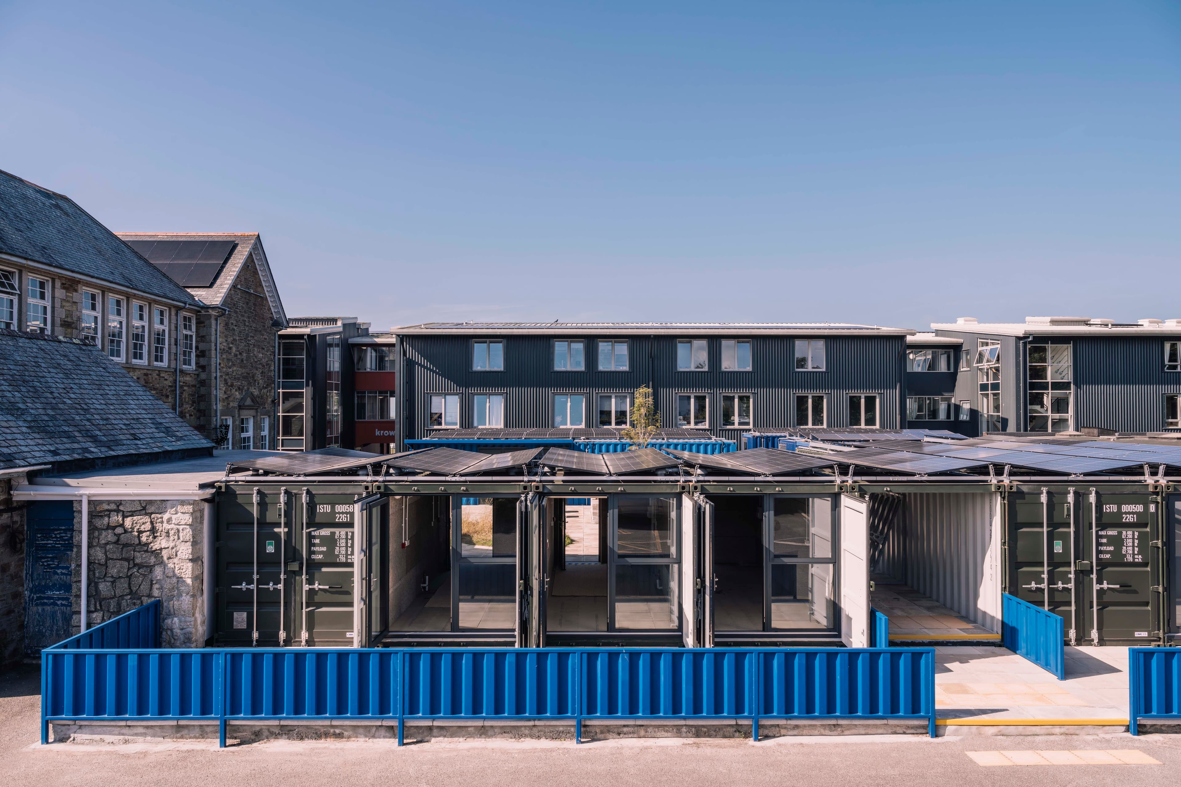 Container studios open onto shared outdoor workspace.