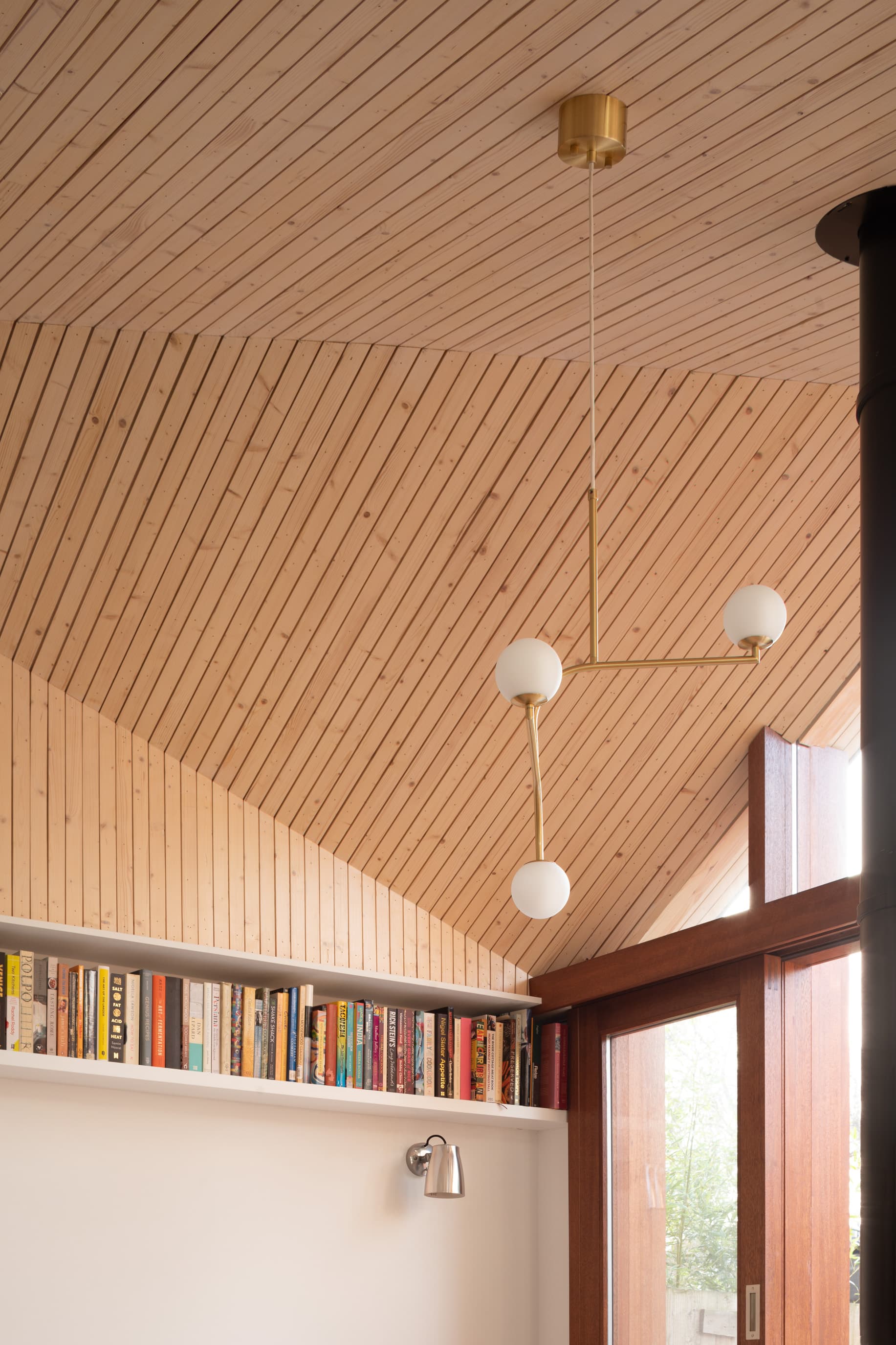 Pendant lights hang below the folded timber ceiling.