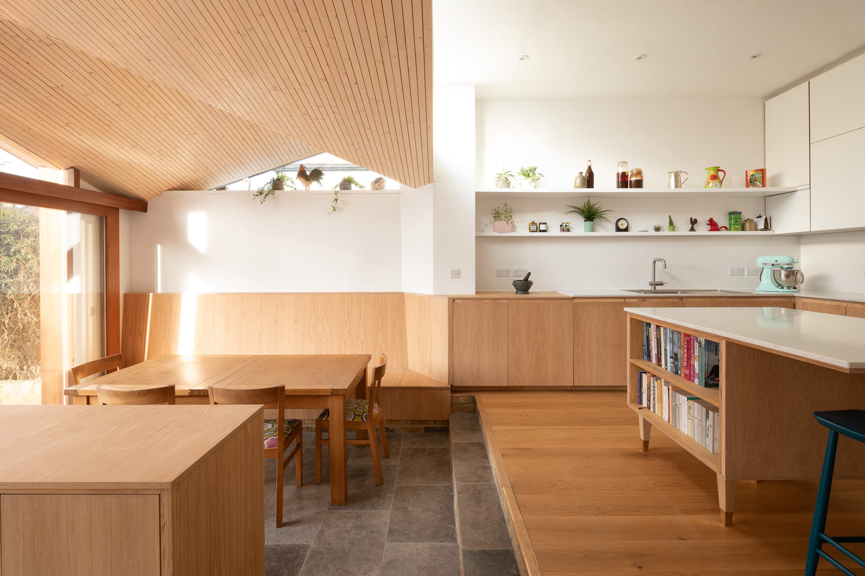 A stepped kitchen island and timber joinery define the cooking area.