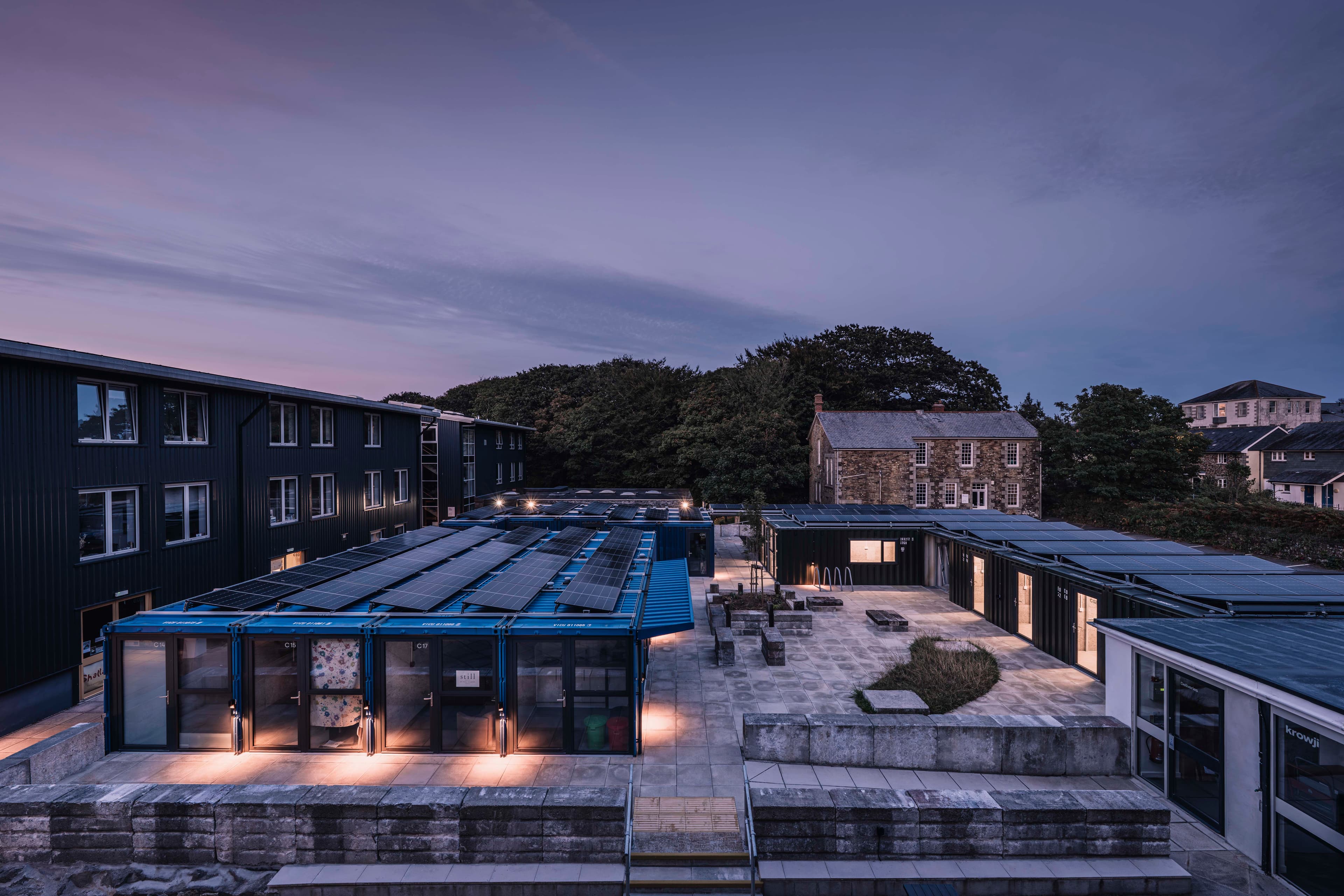 Light from the studios animates the courtyard at dusk.