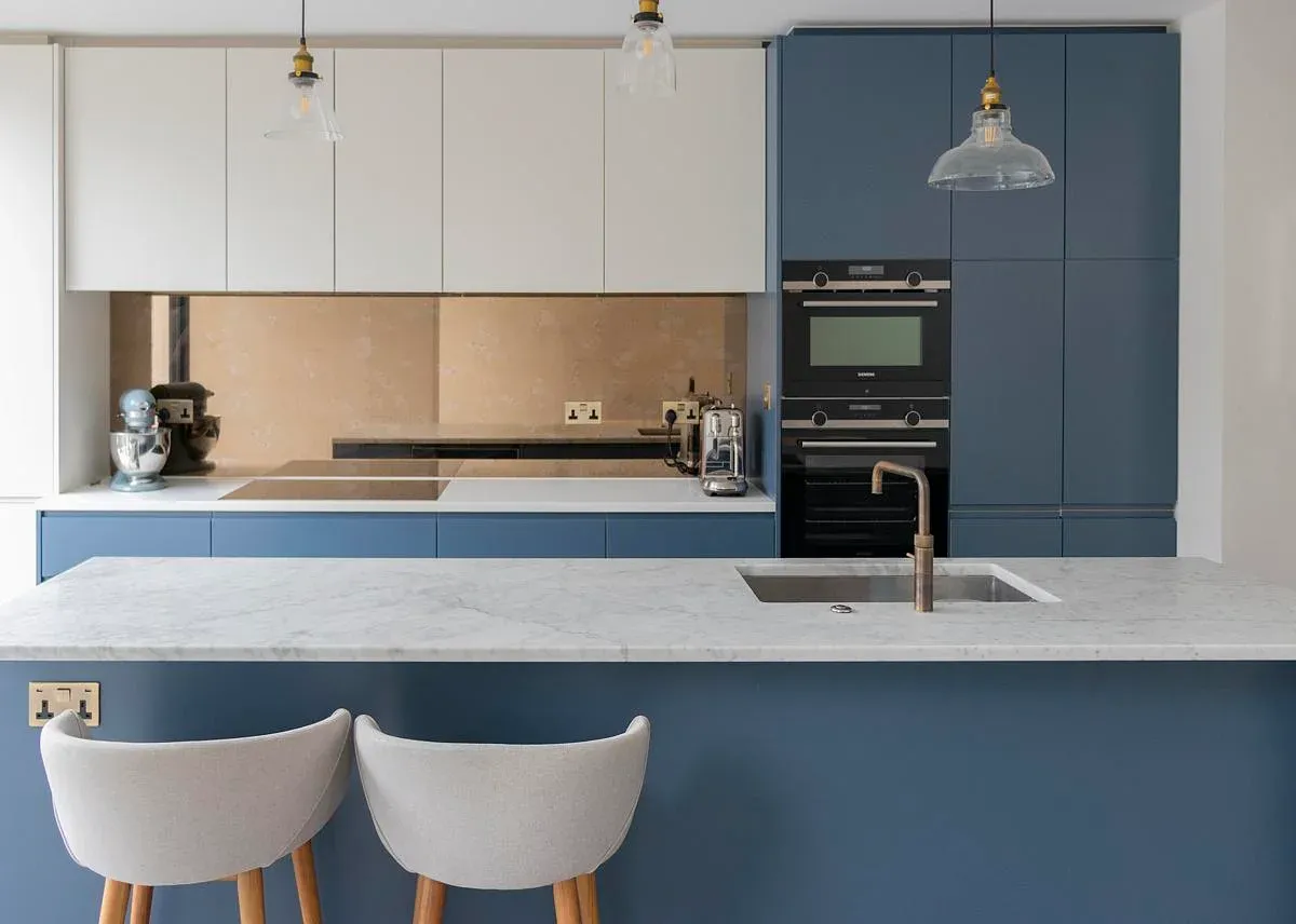 White and blue kitchen cupboards frame the worktop and island.