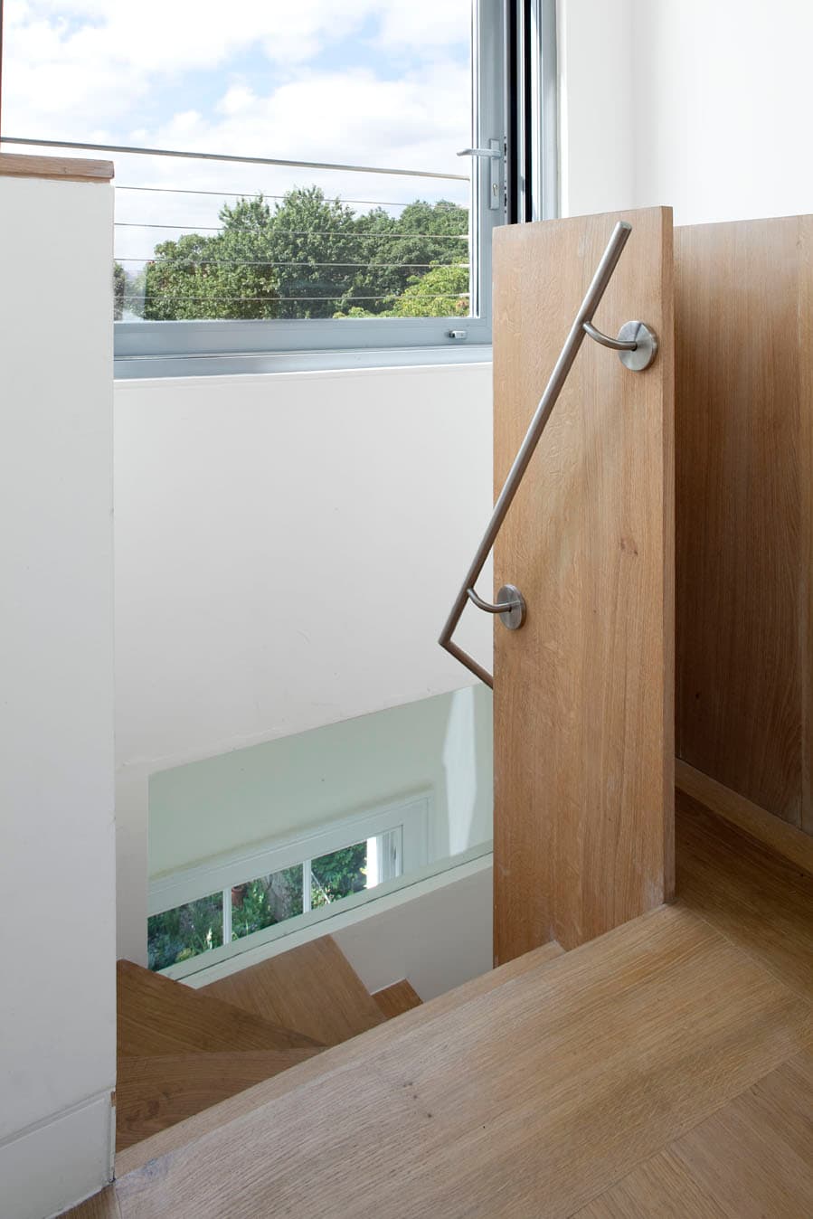 A timber stair rises towards the new upper floor