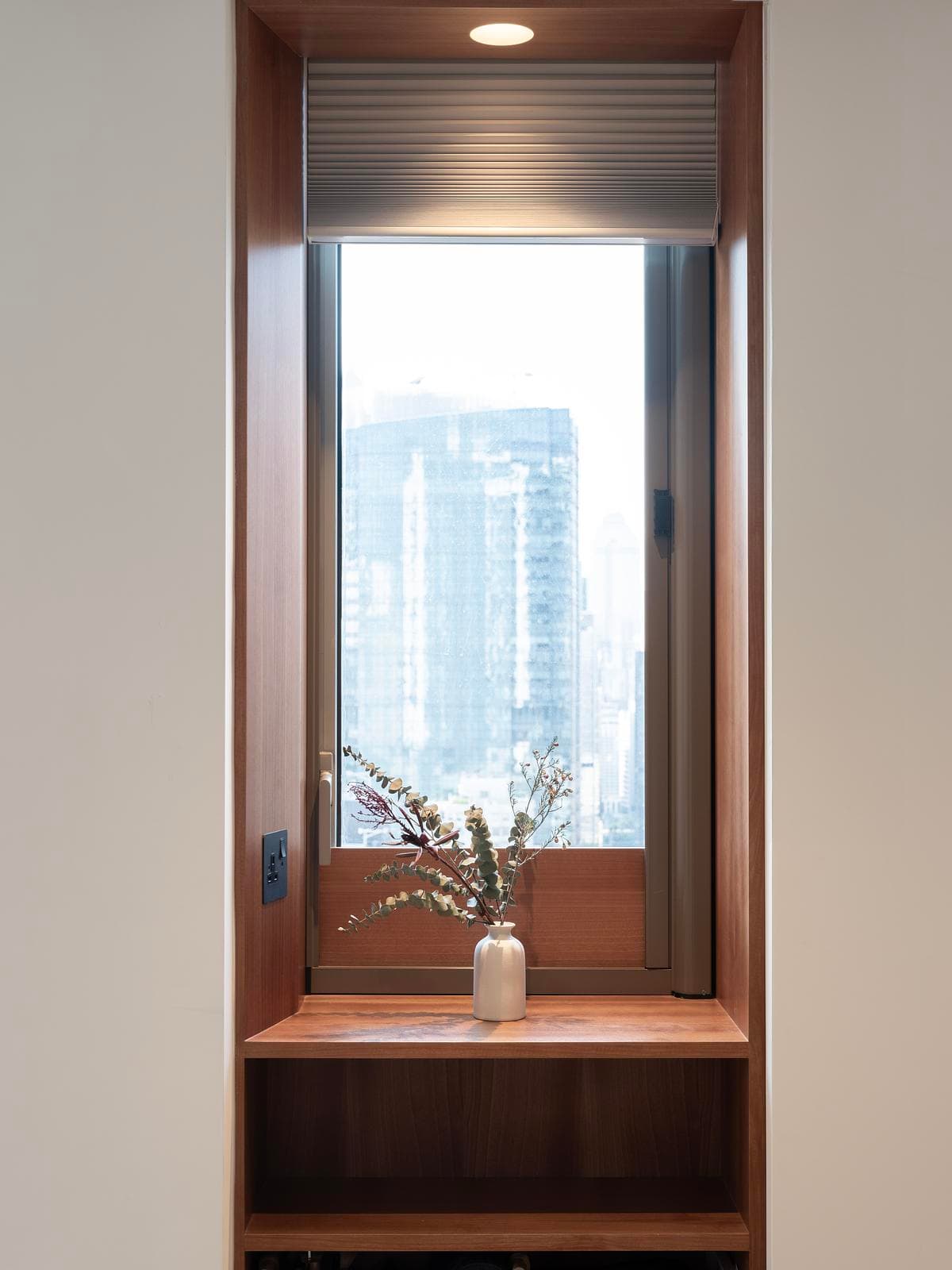 A timber-lined window niche incorporates a small shelf and integrated storage.