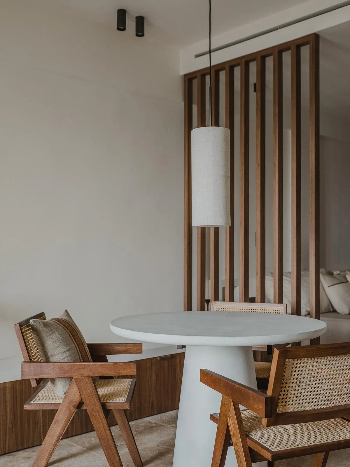 Dining furniture sits beside a full-height timber slatted screen.
