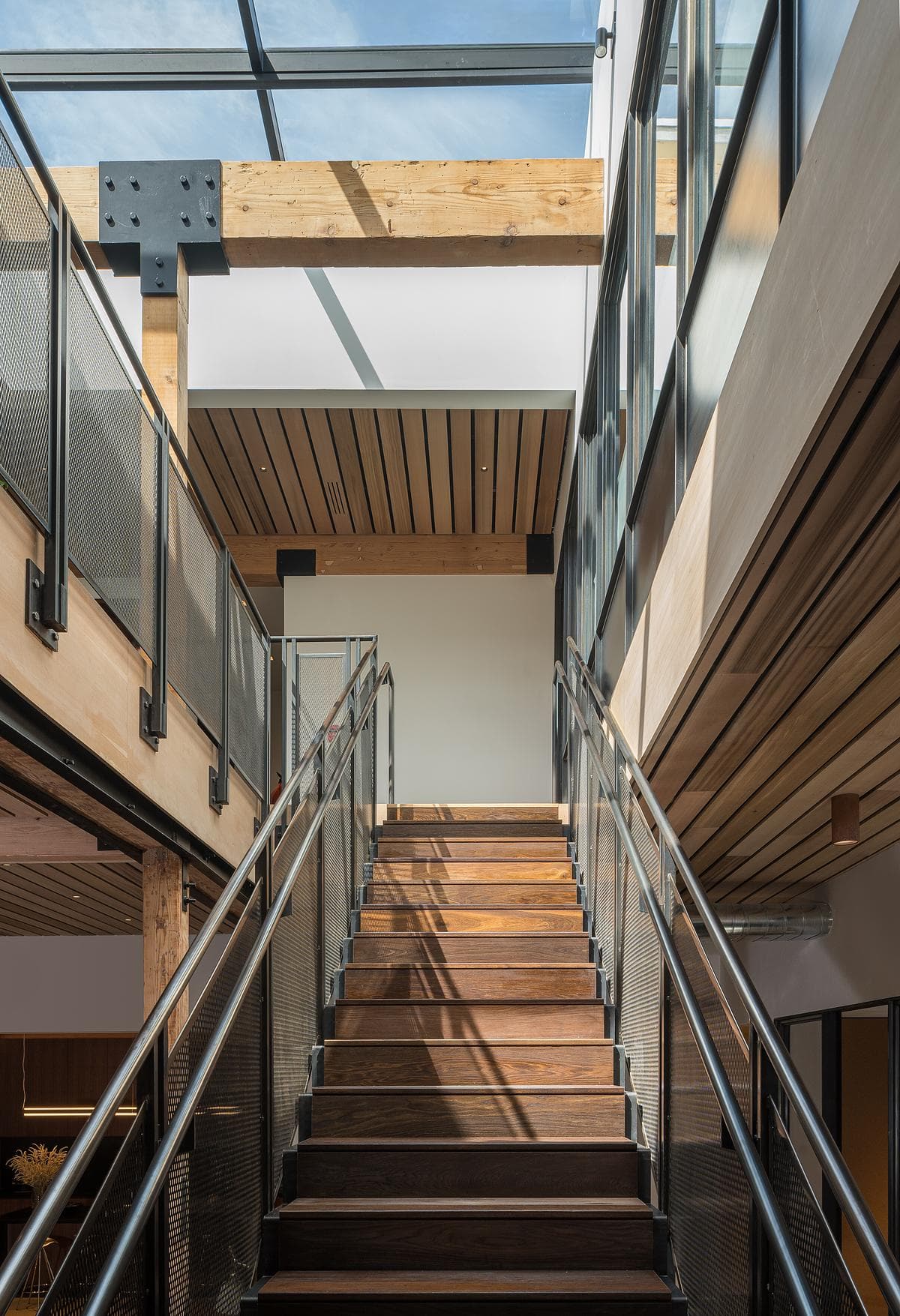 The open stair connects the floors beneath a large skylight.
