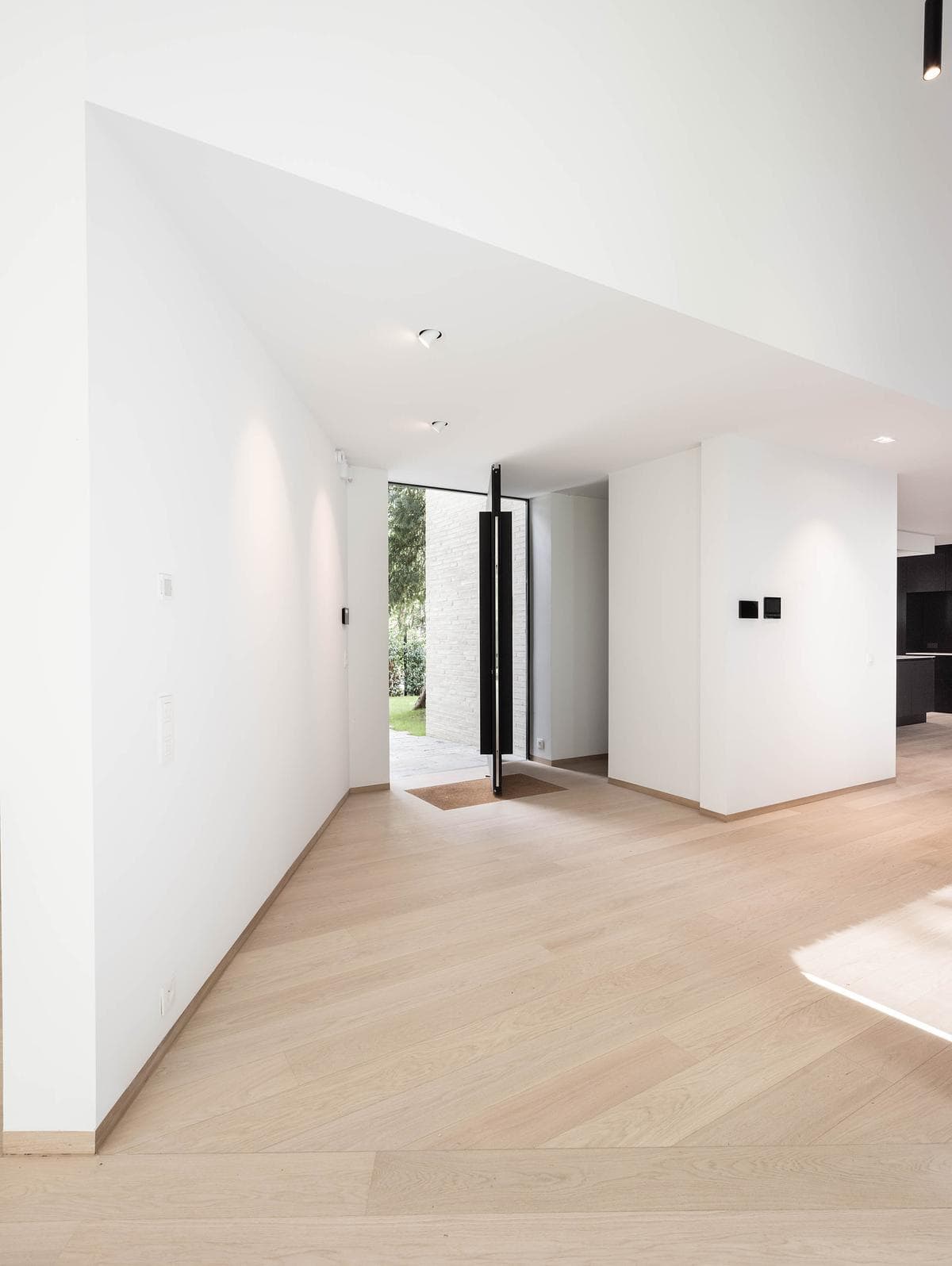 The completed, unfurnished interior connects through a sequence of white volumes.