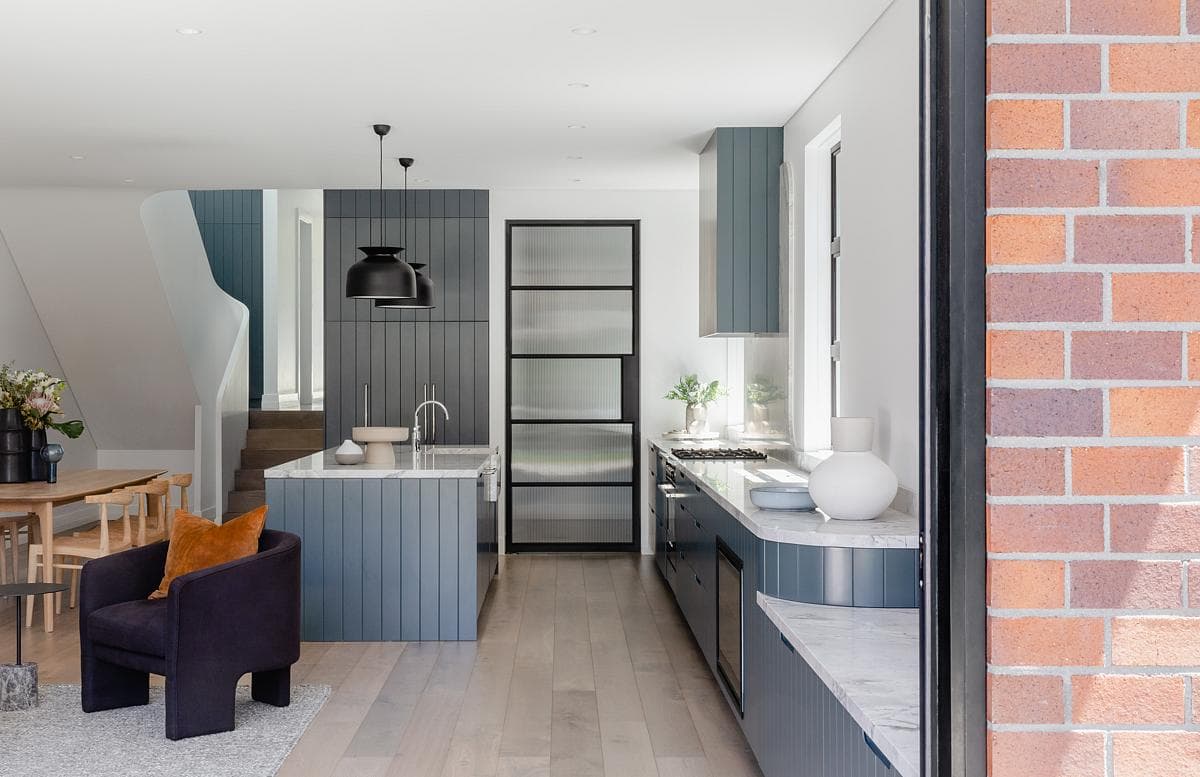 Large openings connect the kitchen and living spaces with the terrace.