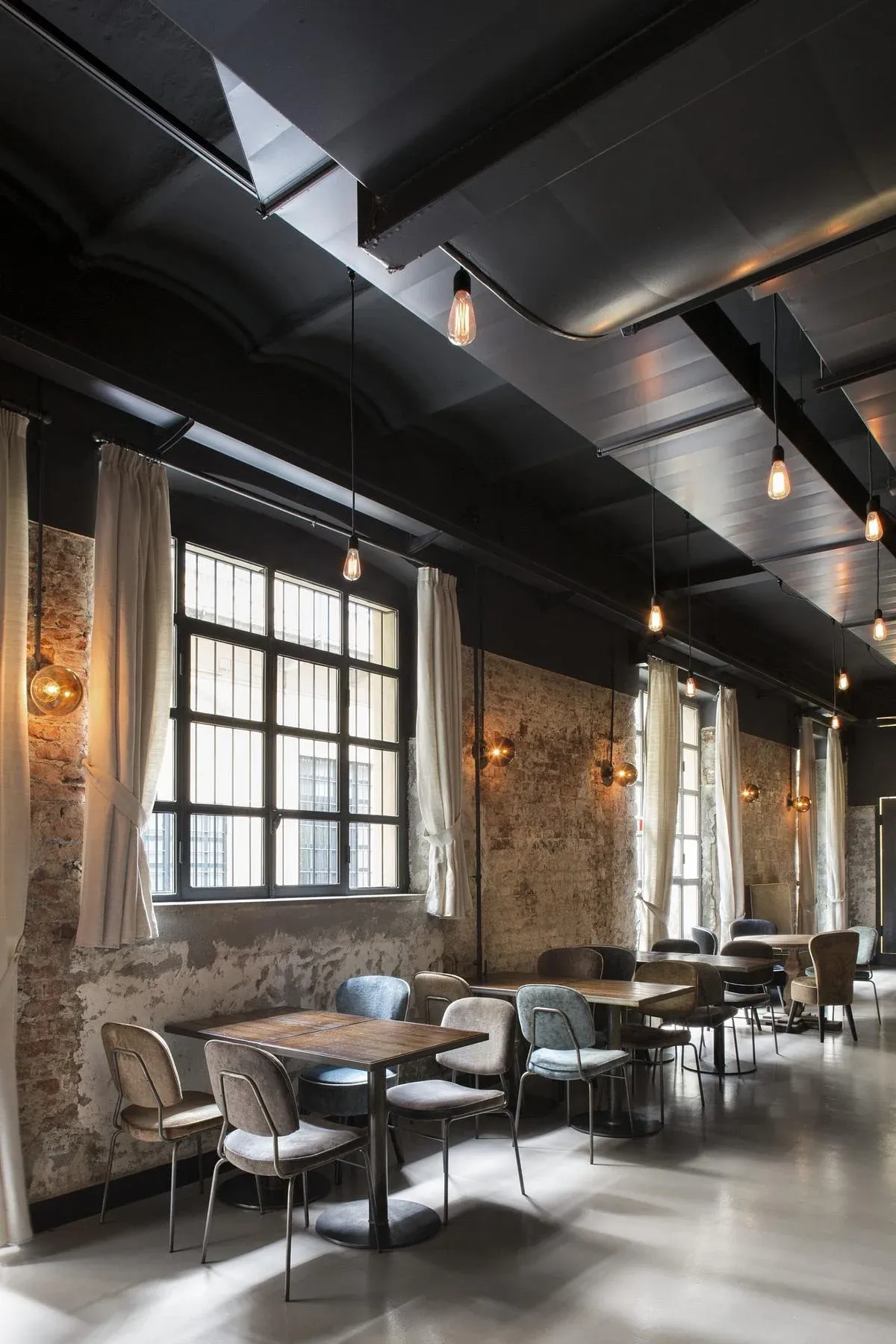 Ceiling services and dark finishes contrast with the pale resin floor.