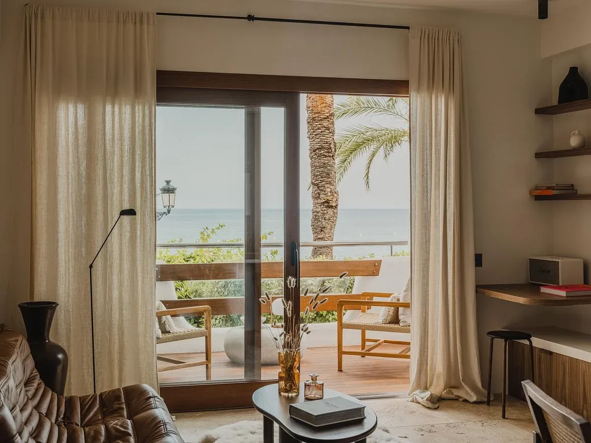 The living room opens onto a balcony overlooking the seafront.
