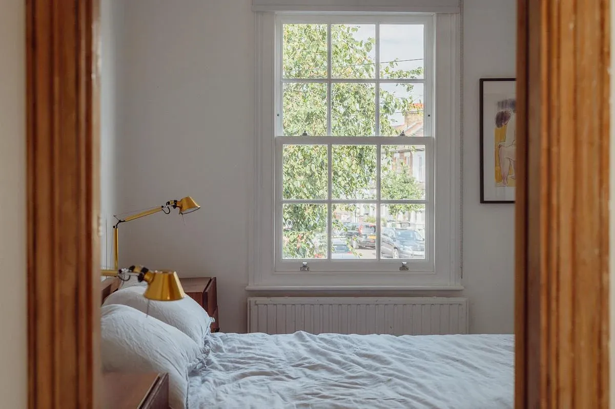 A framed doorway connects the timber-lined interior with the bedroom.