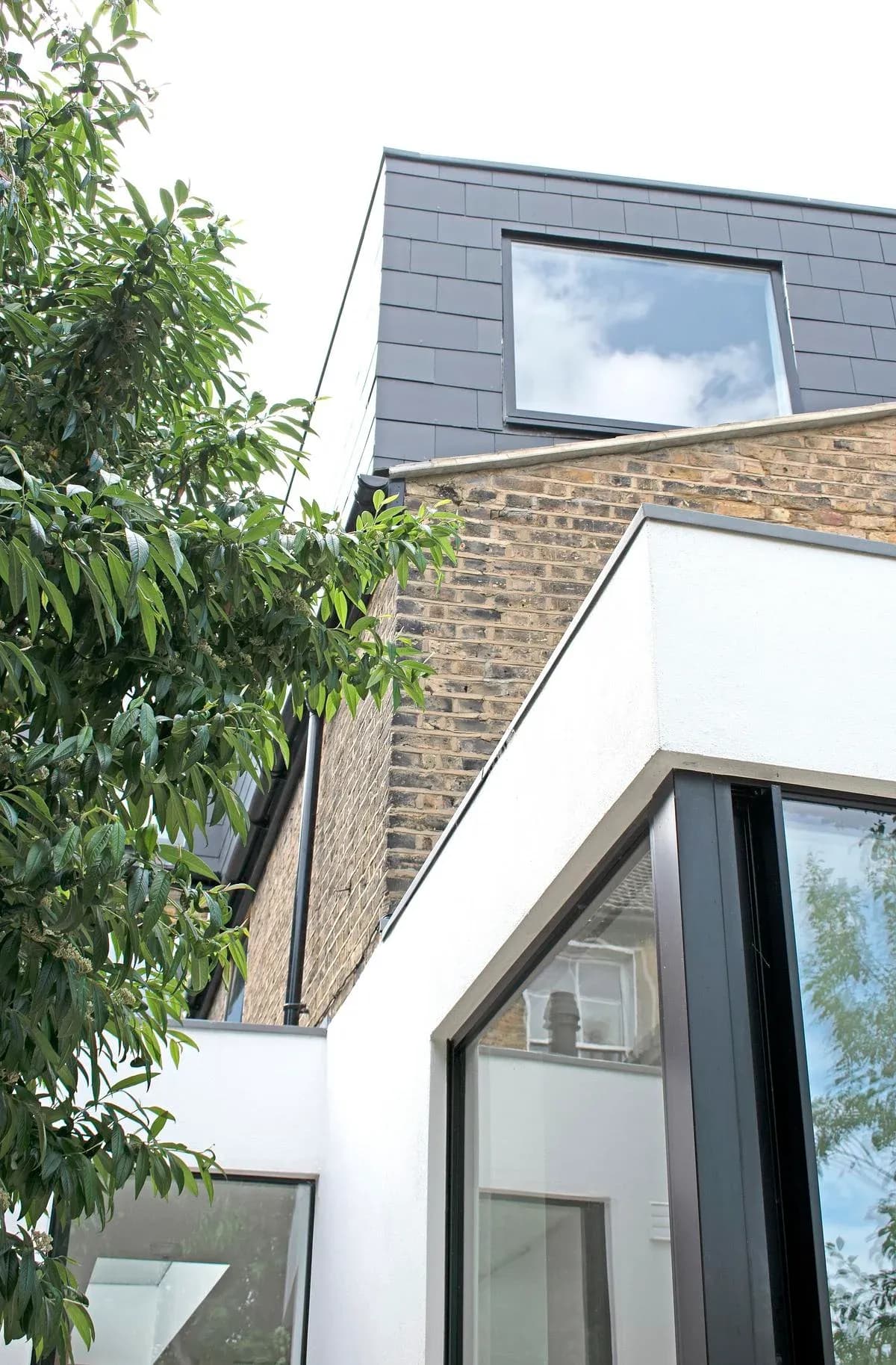 Slate-clad roof additions sit above the white rear extension.