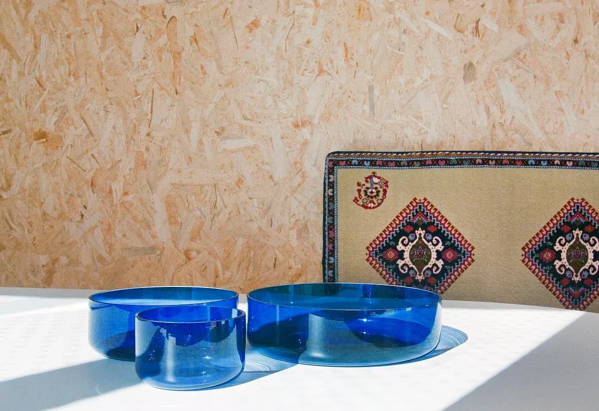 Blue tableware sits against the textured OSB wall.