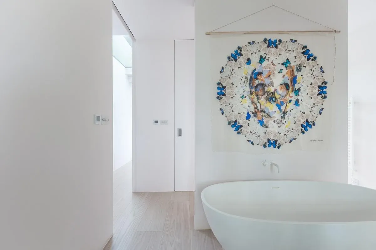 Freestanding bath and artwork in an upper-level room.