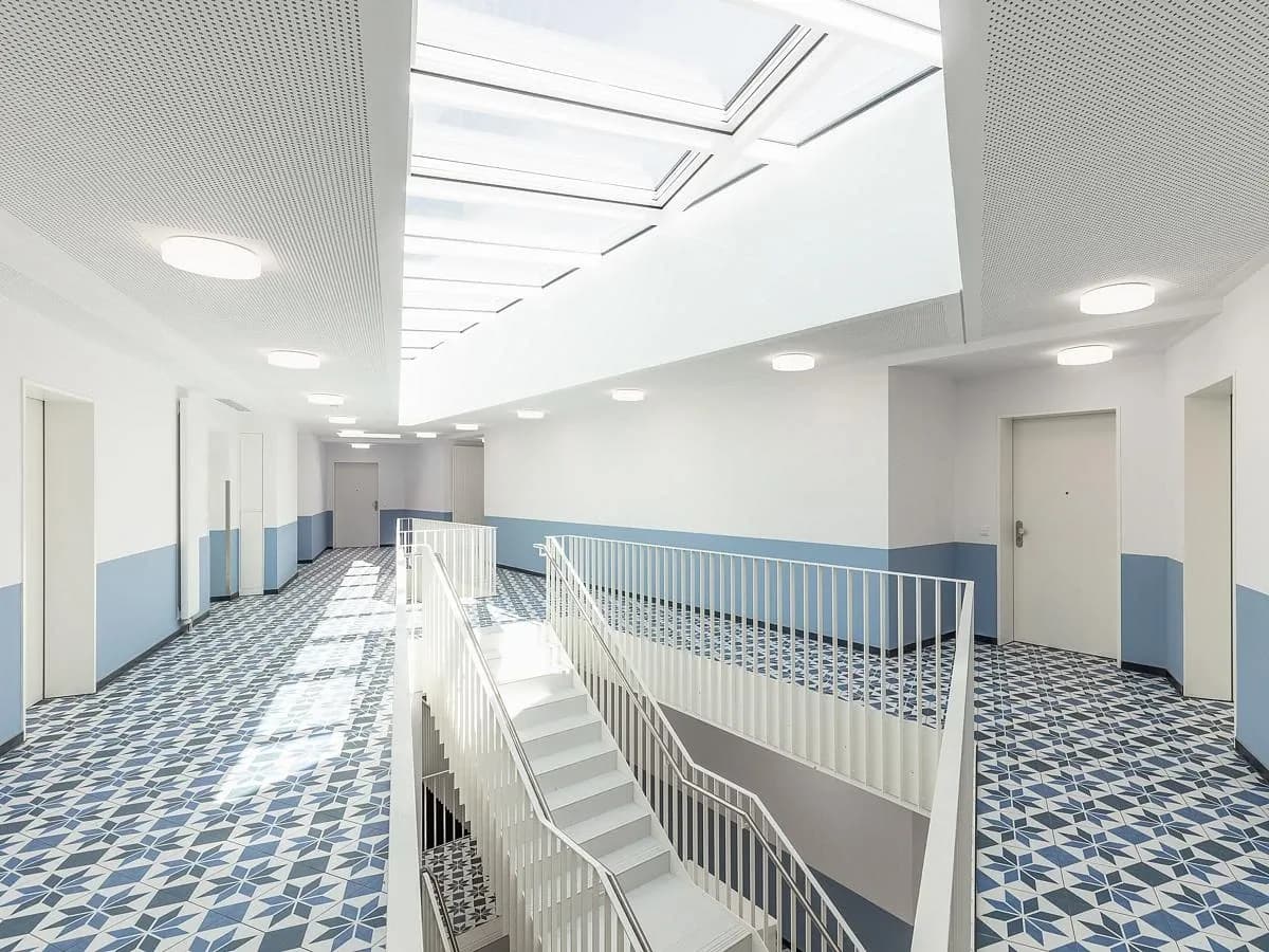 A skylit stair hall links the floors with open, white-railed stairs.