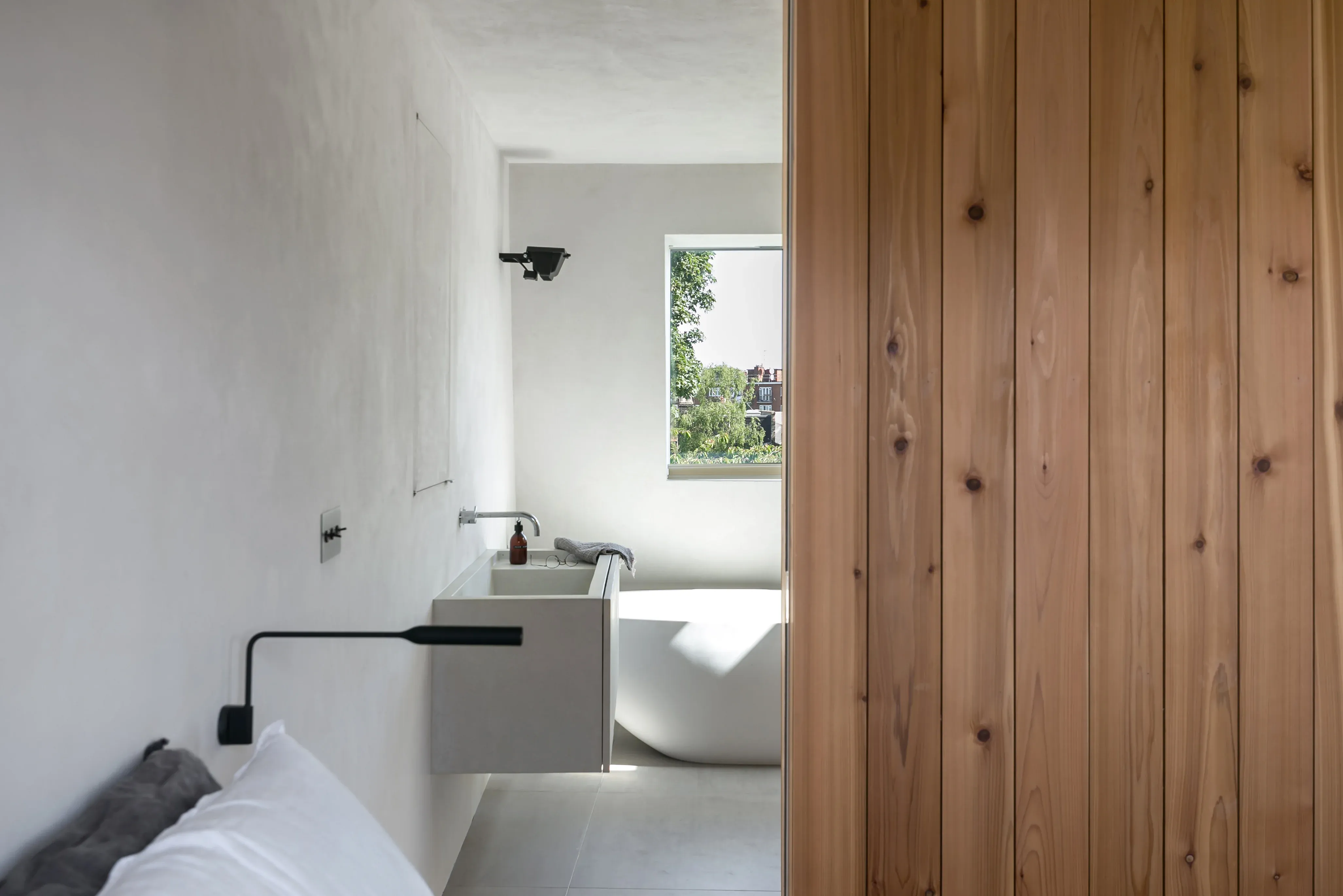 Timber lining and a pale bathroom interior continue the shared material palette.