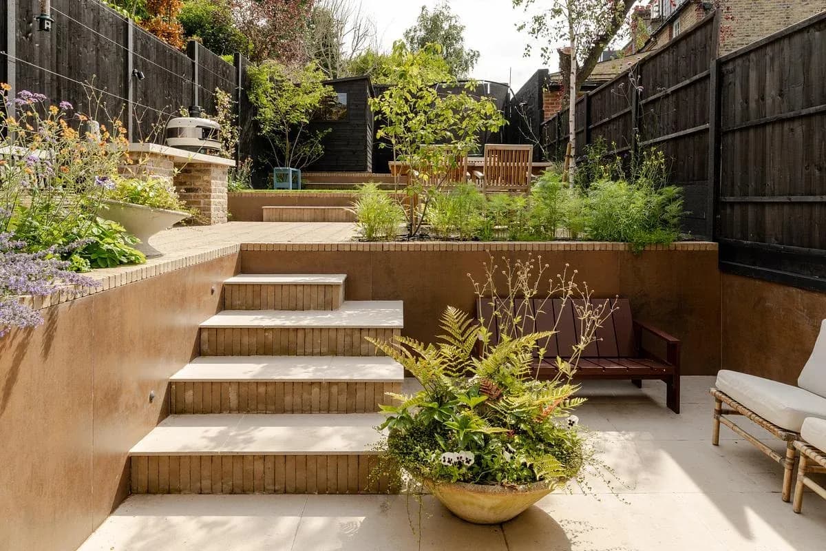 Planted terraces and steps connect the rear rooms to the garden.