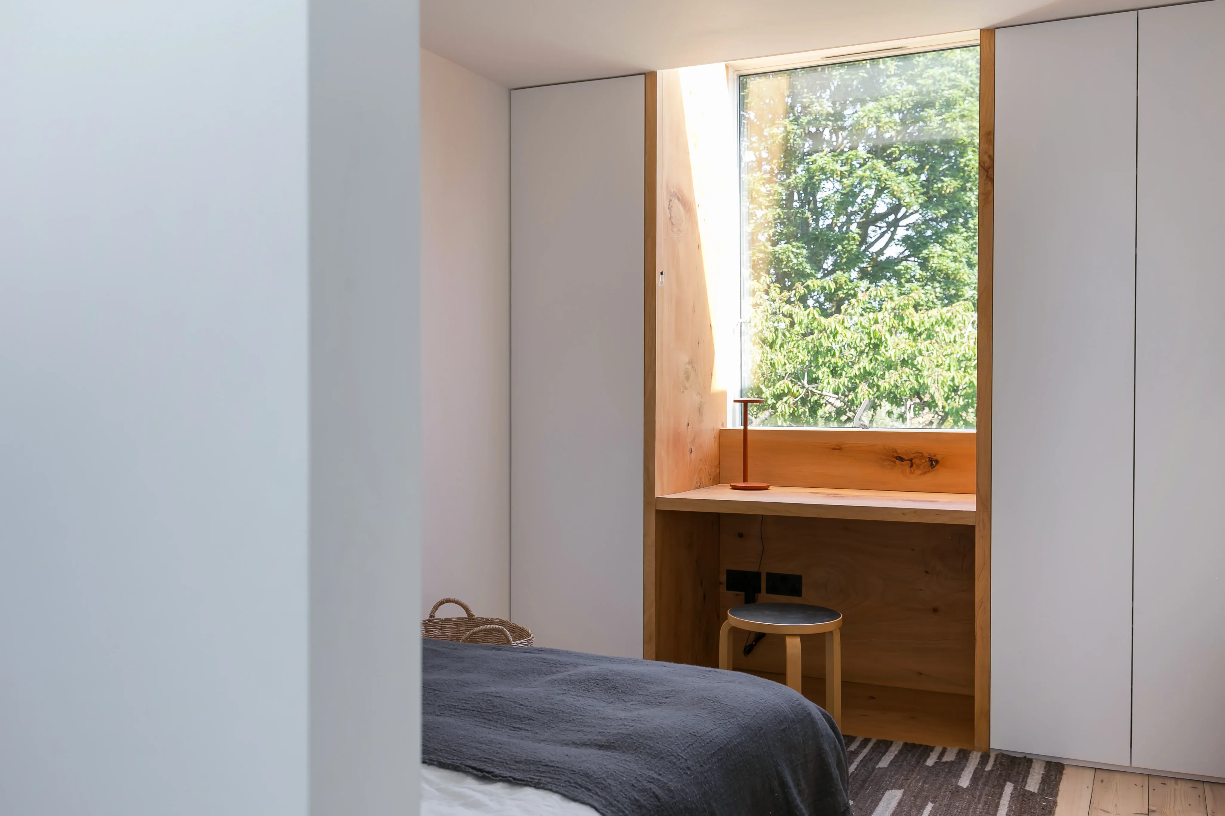 A timber-lined desk and window surround frame the view outside.