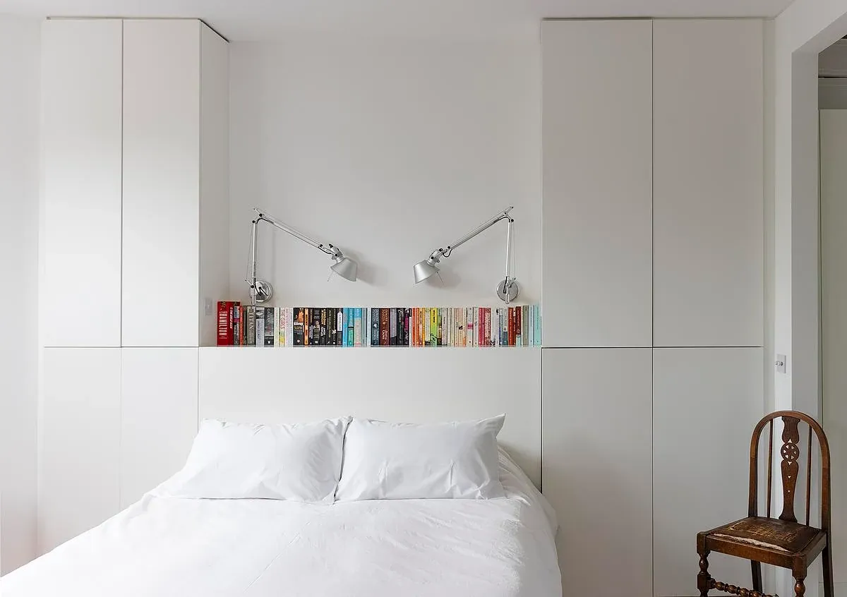 A white storage wall frames a bedroom at Diorama 2.