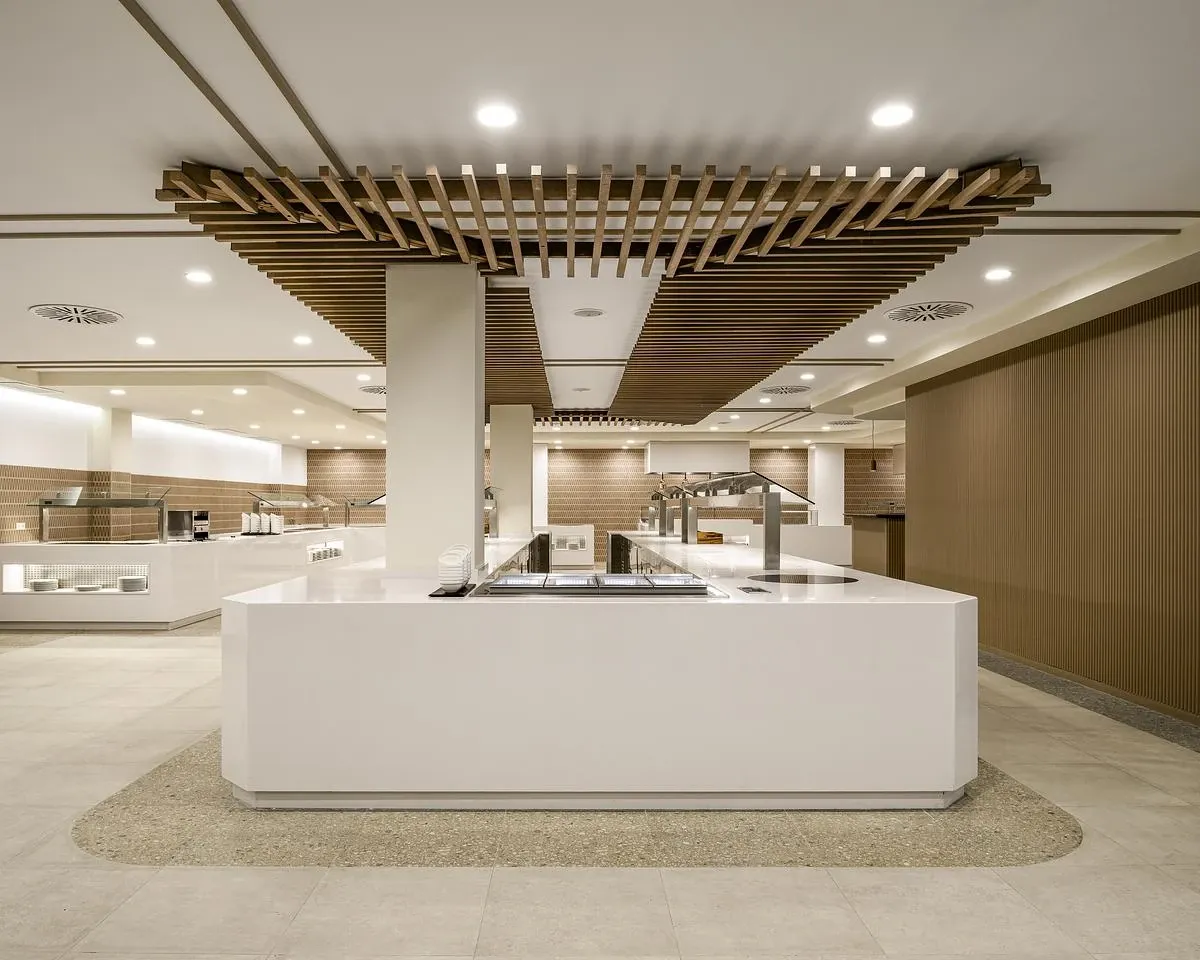 Timber louvres hang above a central buffet island framed by curved ceiling bands.