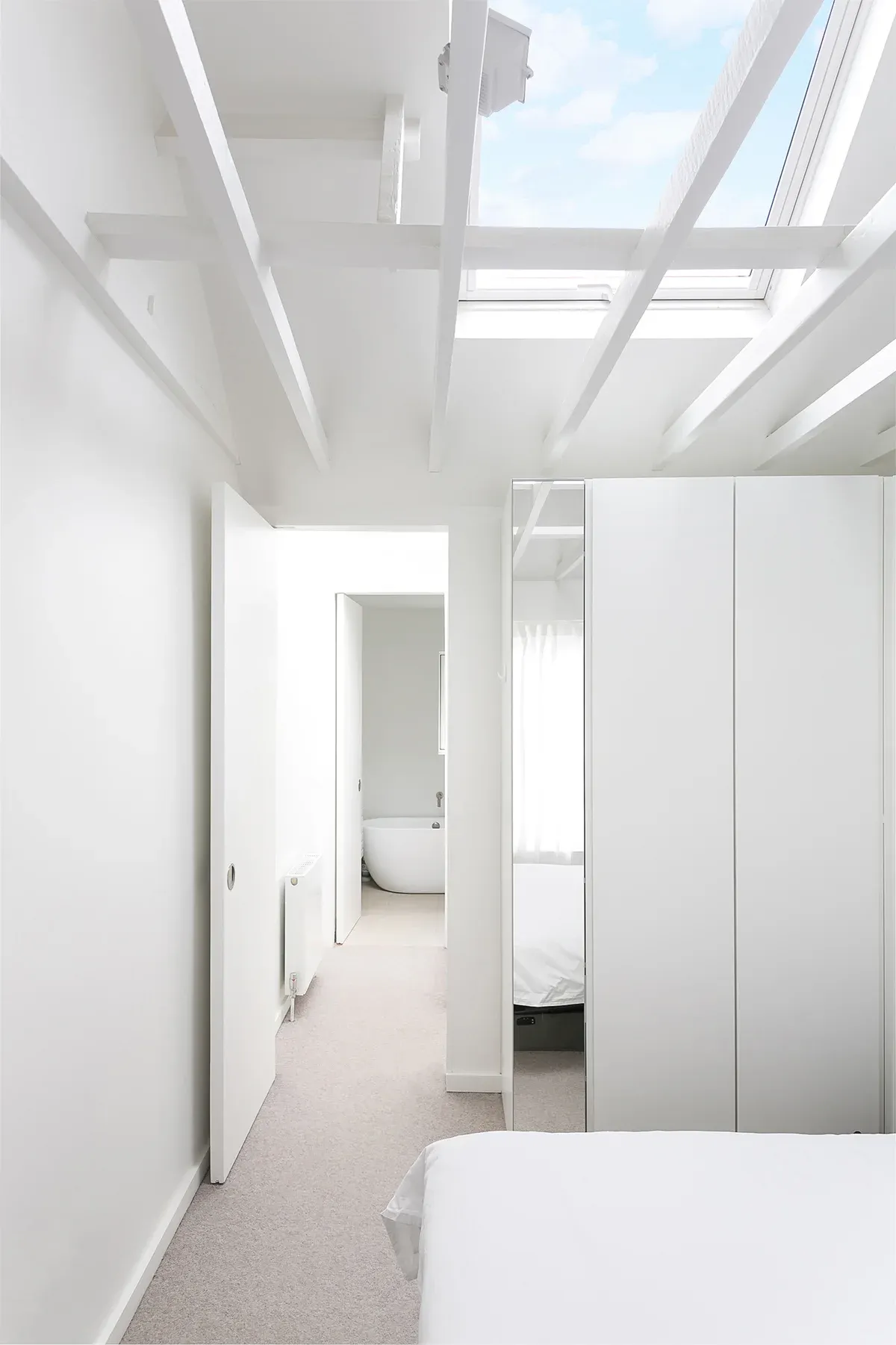 A rooflight and exposed structure extend the view along the upper floor.