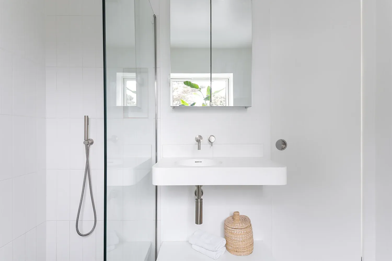White tiles and a walk-in shower keep the compact bathroom visually simple.
