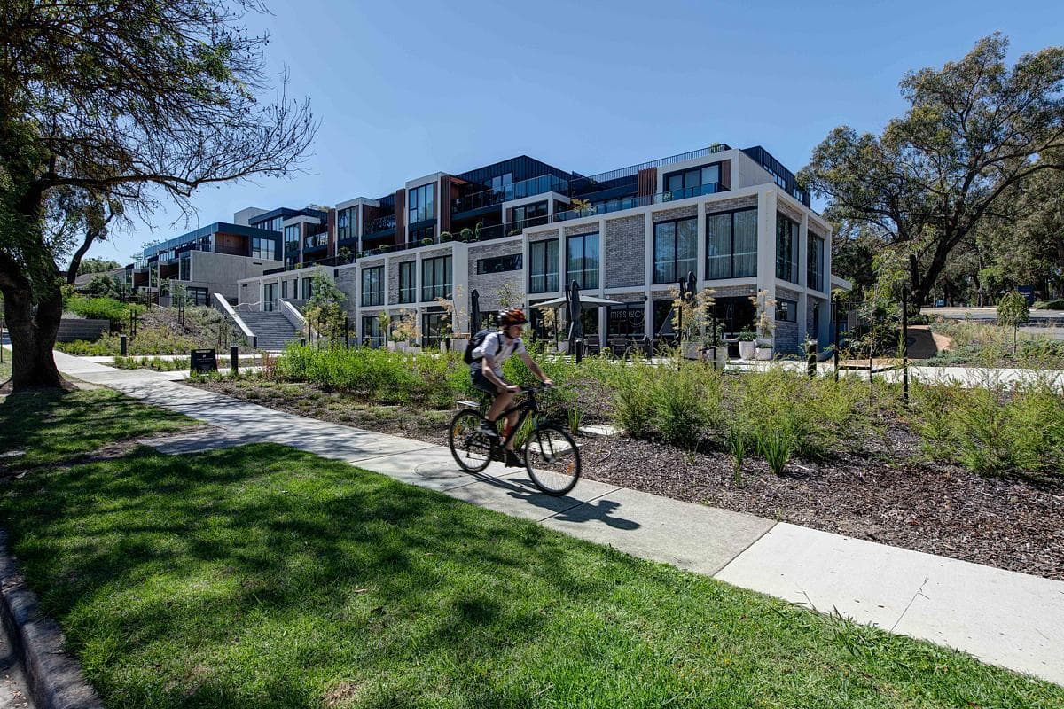 Low-rise buildings sit beside landscaped walking and cycling routes.