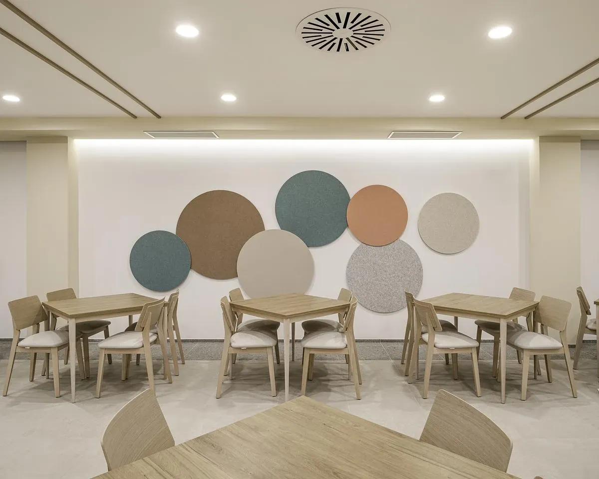 Circular wall panels in soft greens and terracotta bring colour to the dining area.