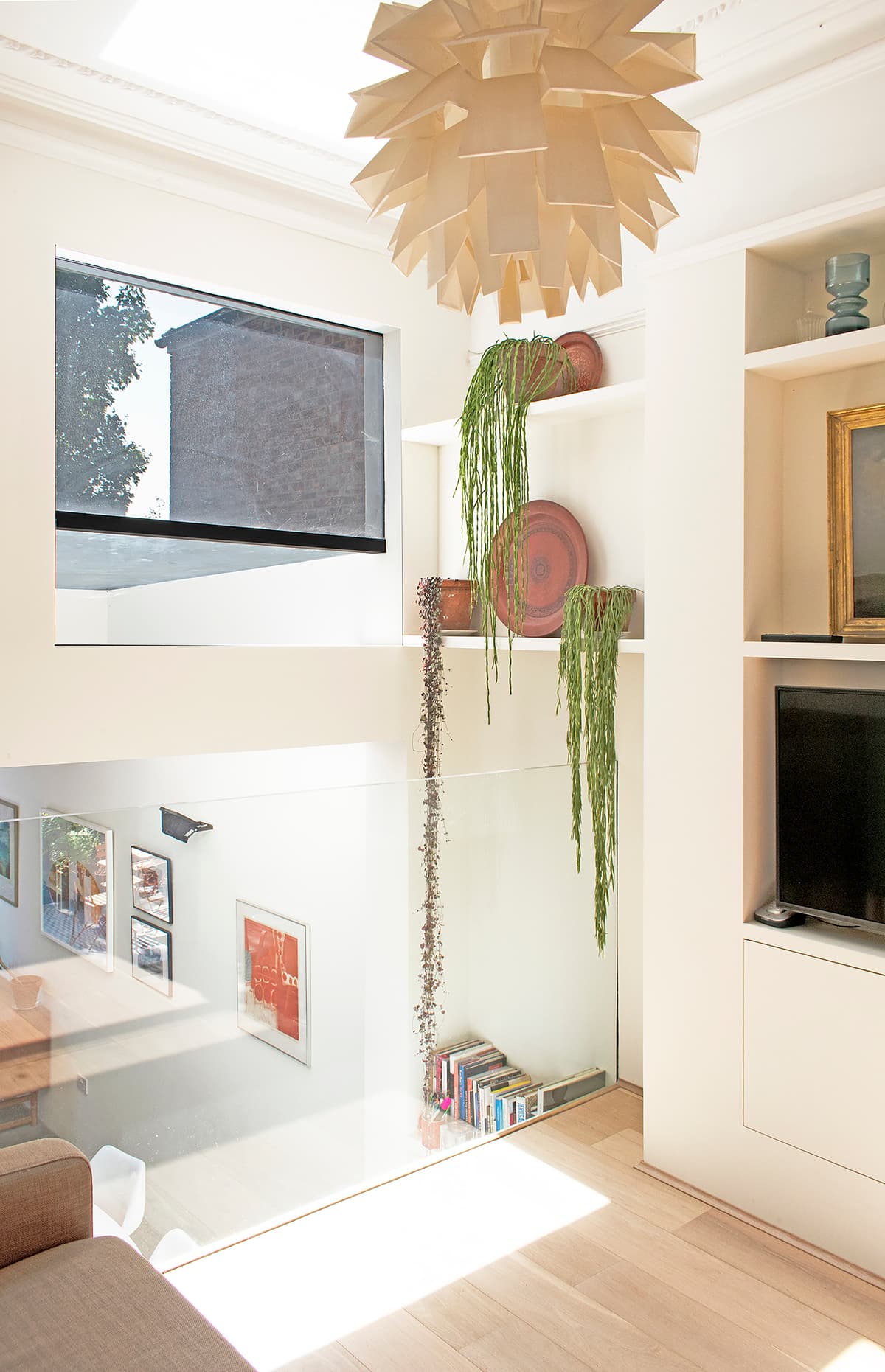 A glass balustrade lets the upper living area overlook the dining space at Structuralist House.