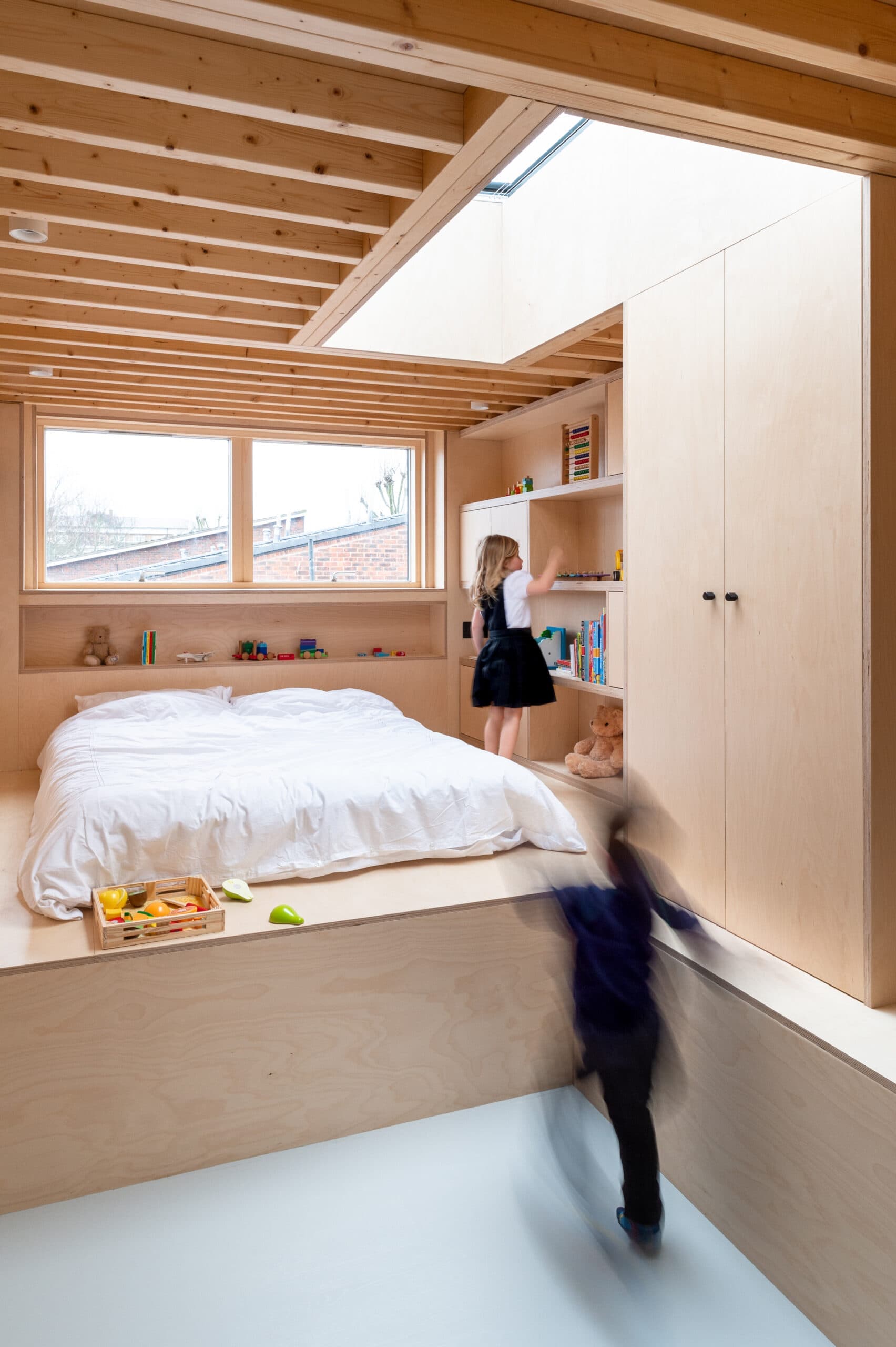 Bedroom with plywood walls and joinery.