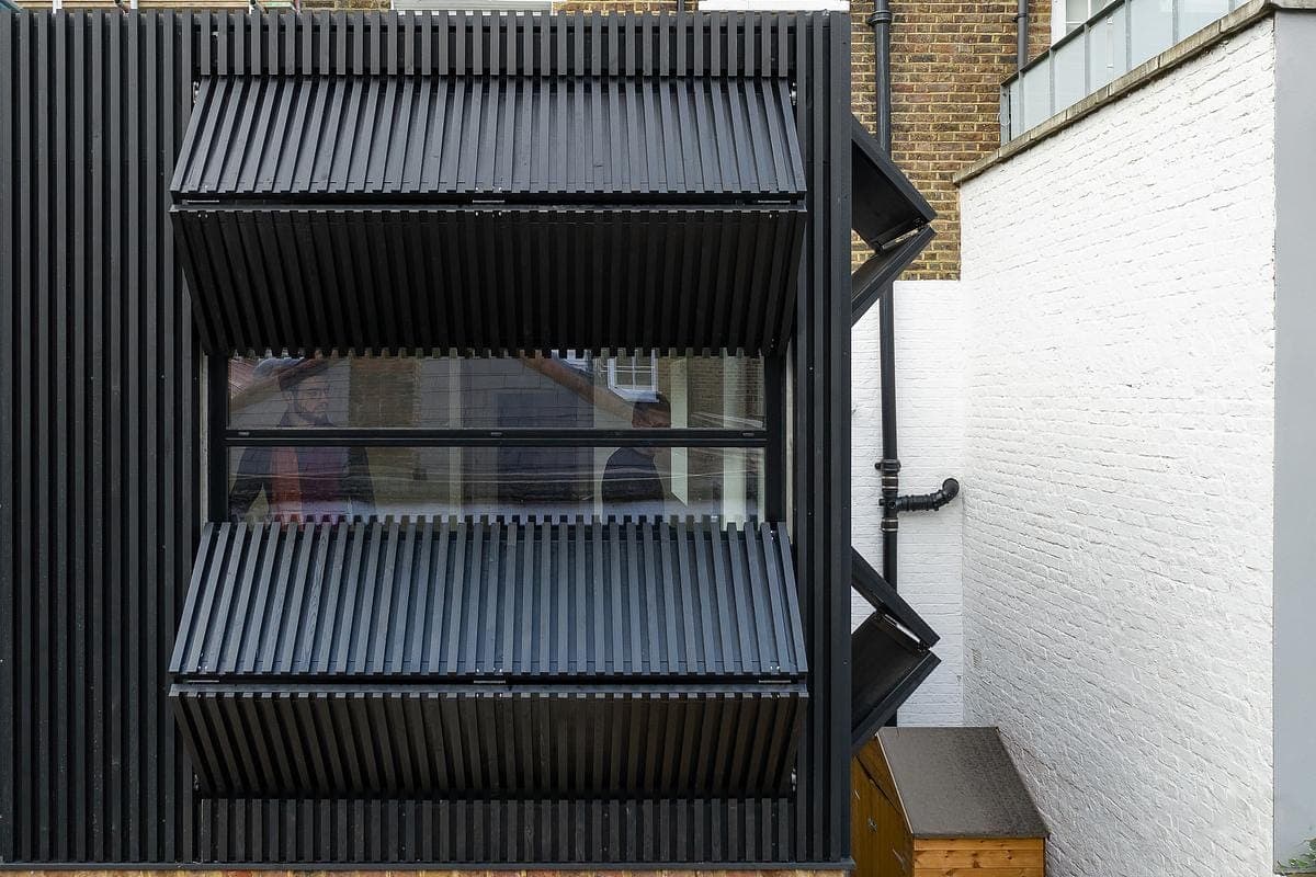Close view of the open window and dark timber shutters.