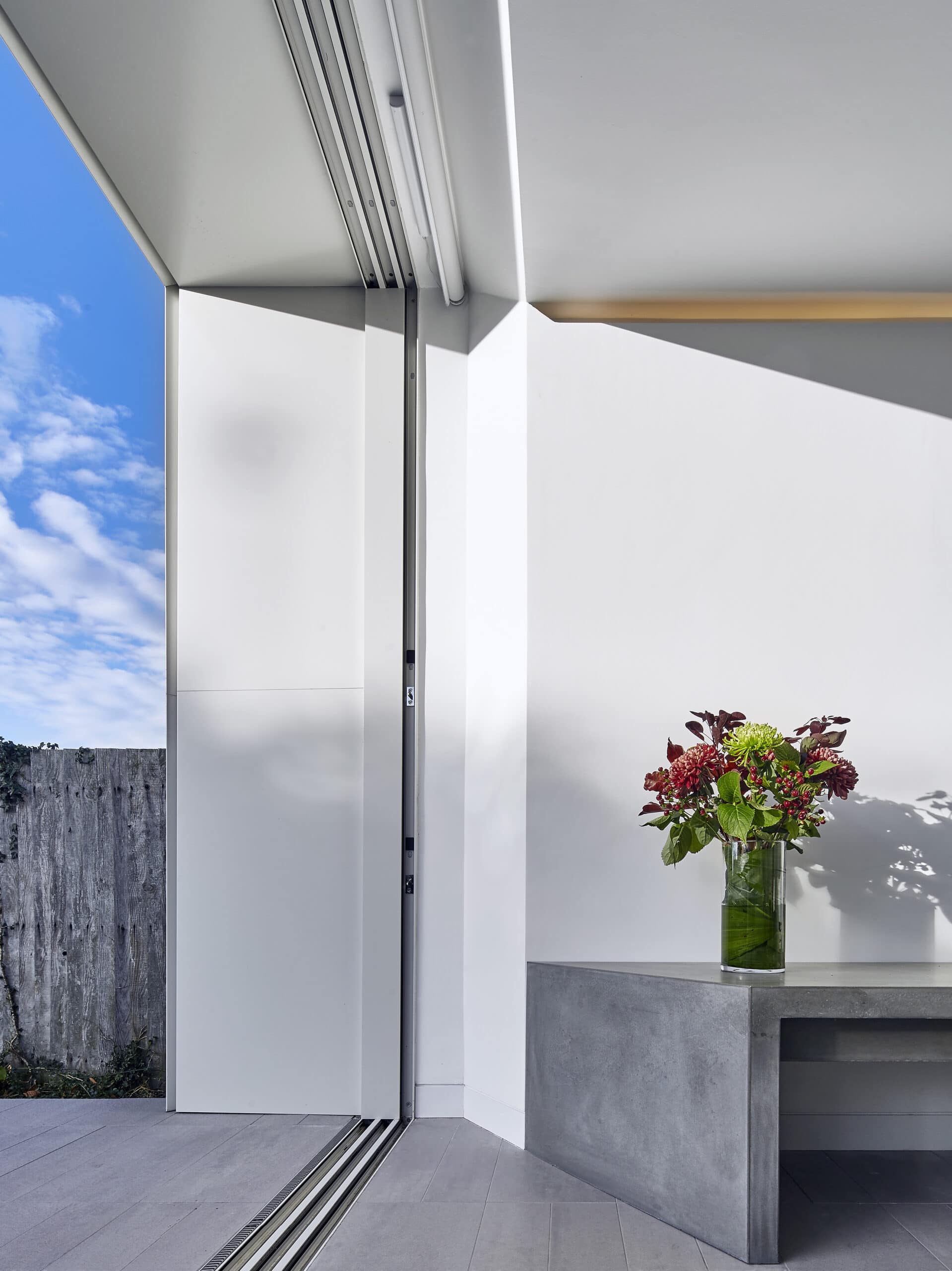Detail of glazing, structural beam and flowers.