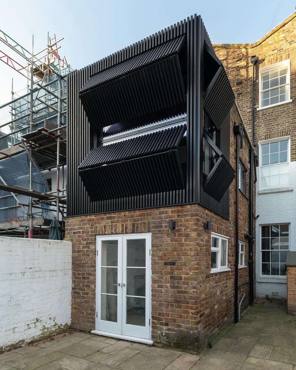 Angled exterior view of the house and neighbouring context.