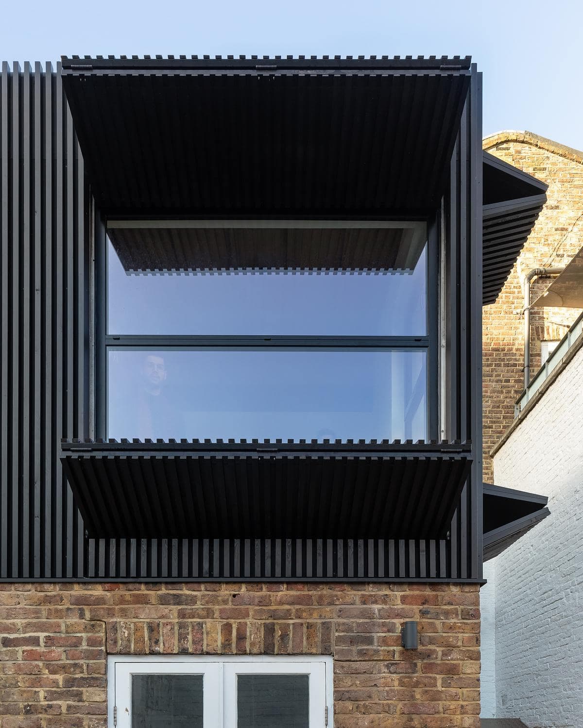 Dark timber shutters opened across the rear facade.